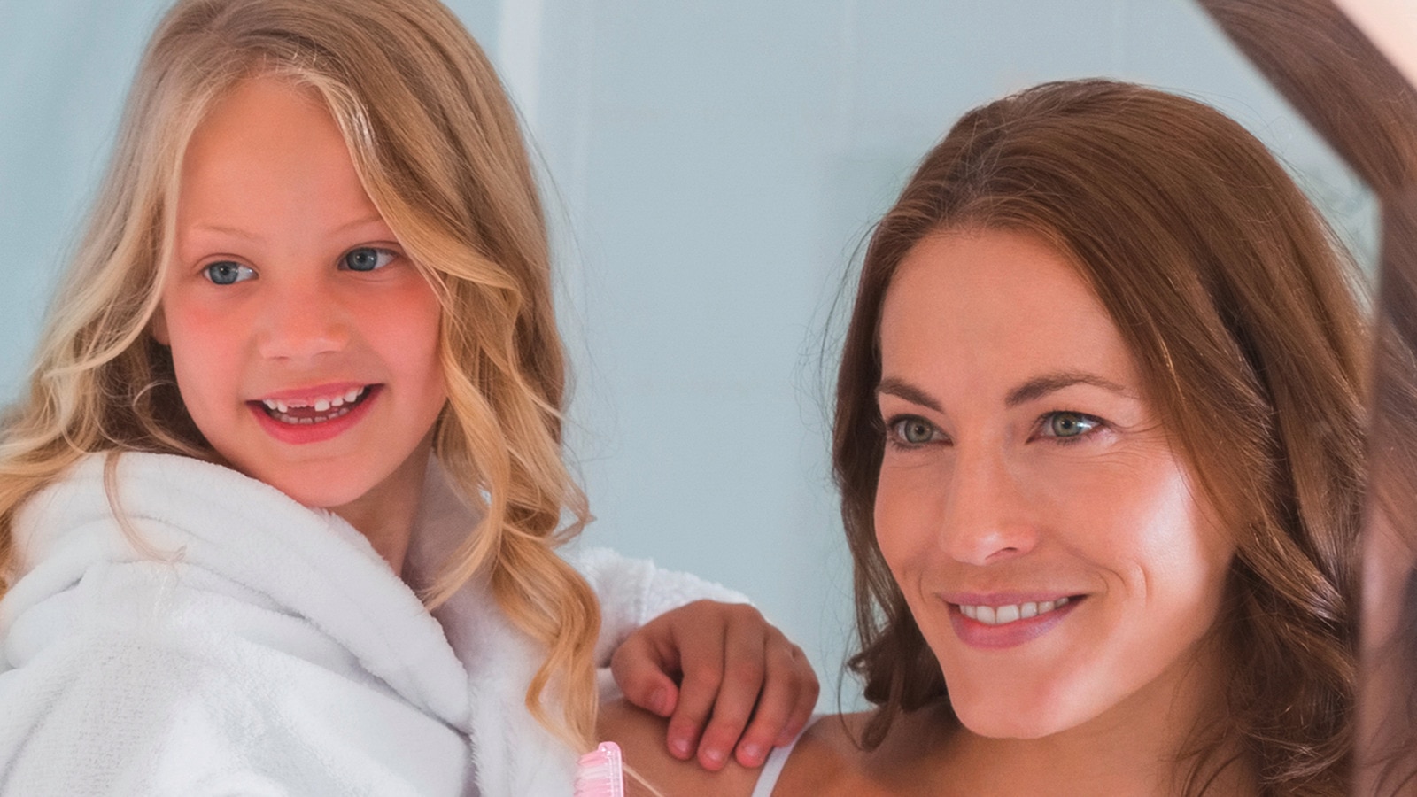 una madre che sorride con un bambino a cui manca un dente