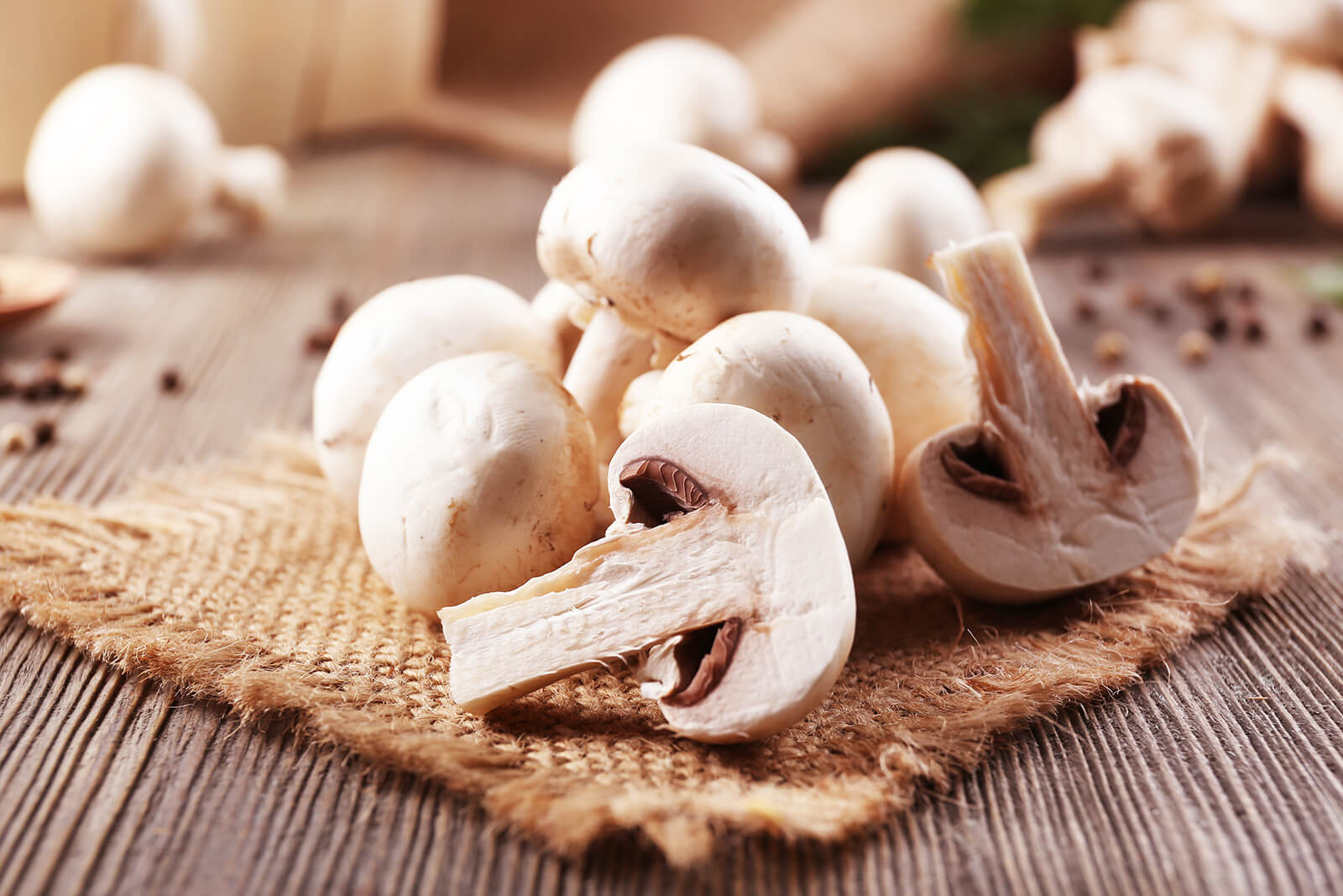 Jamur champignon ditata di atas tatakan karung goni di atas meja kayu