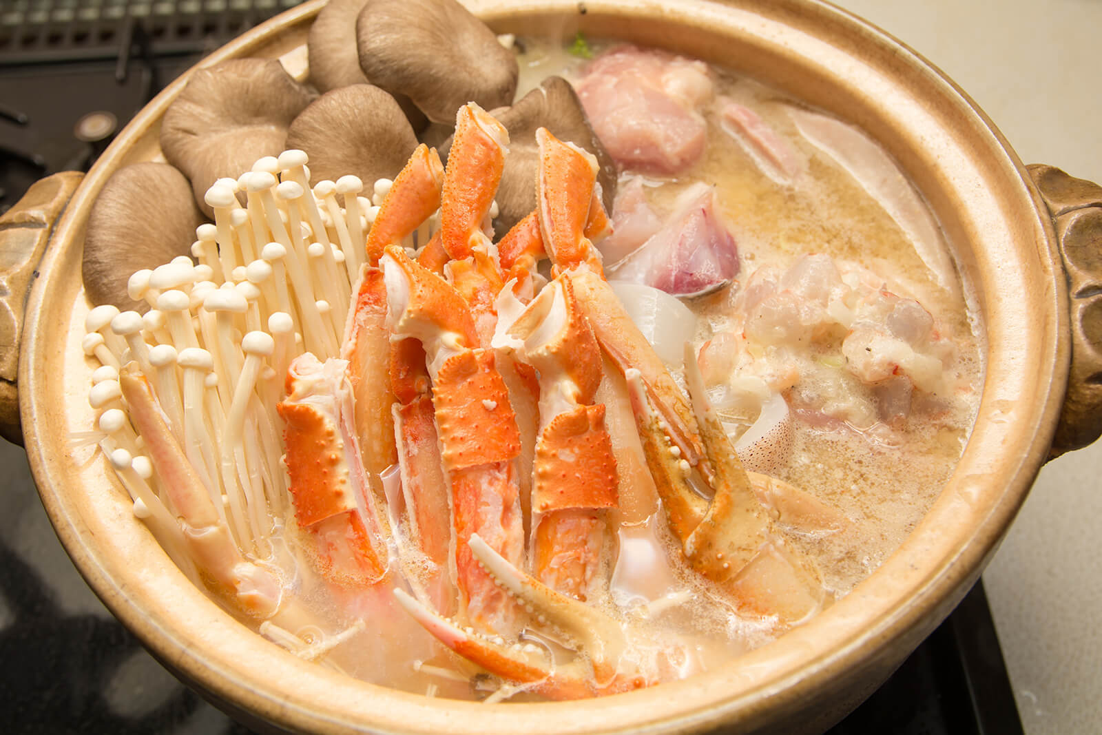 Makanan hotpot kepiting tengah dimasak bersama jenis-jenis jamur seperti shiitake dan enoki