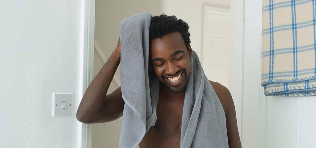 Man smiling with a towel on his hand