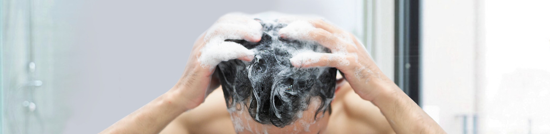 Homem passando shampoo no cabelo