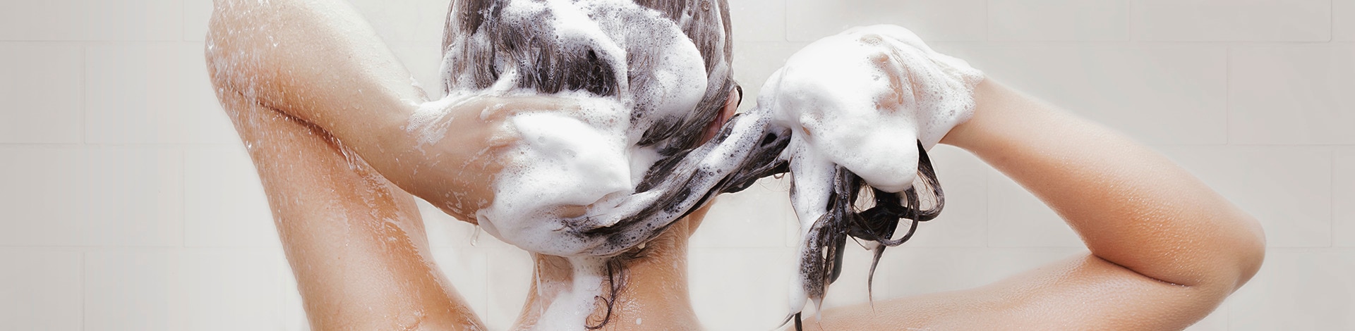 Women lathering hair with shampoo