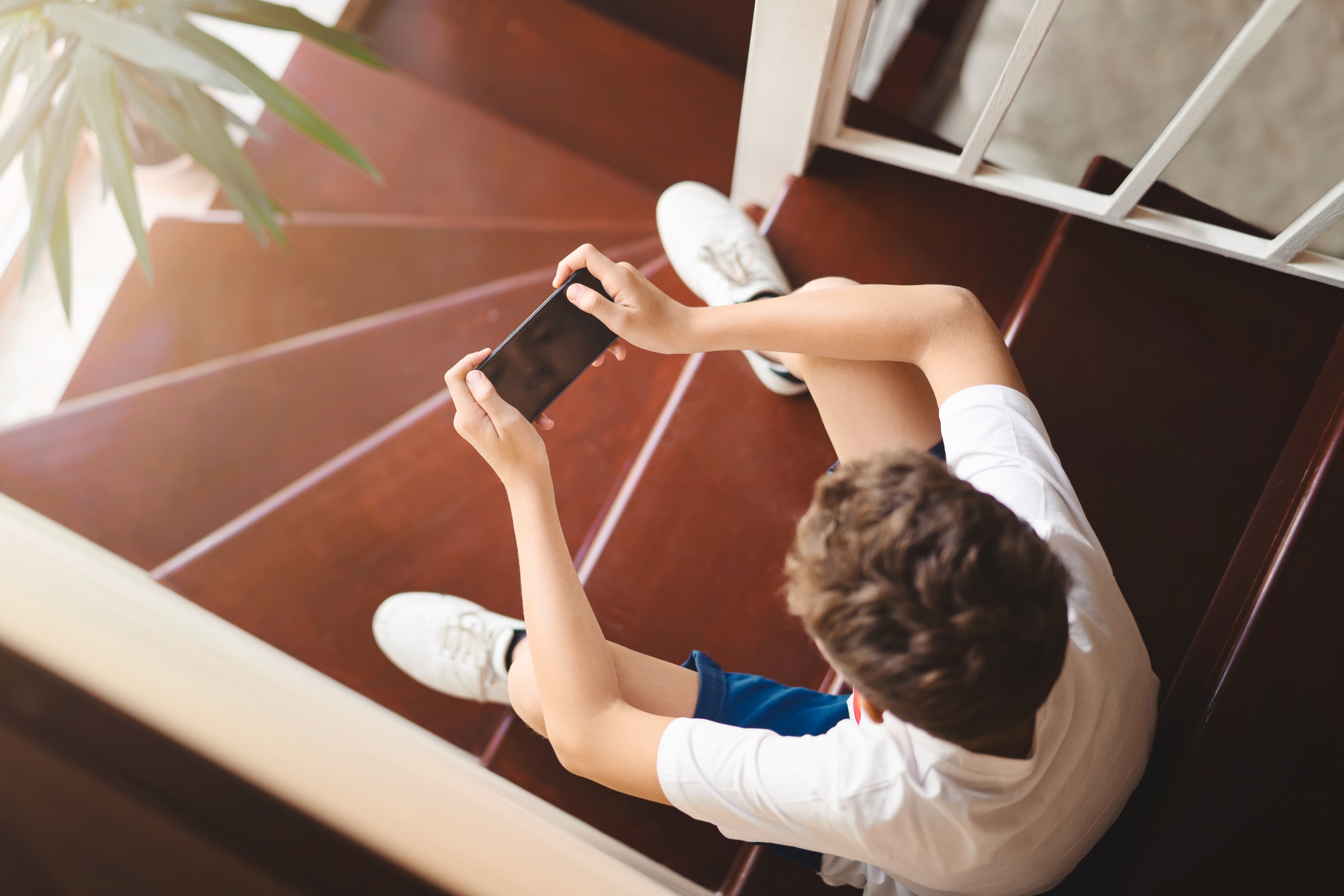 Aerial shot of guy on stairs texting