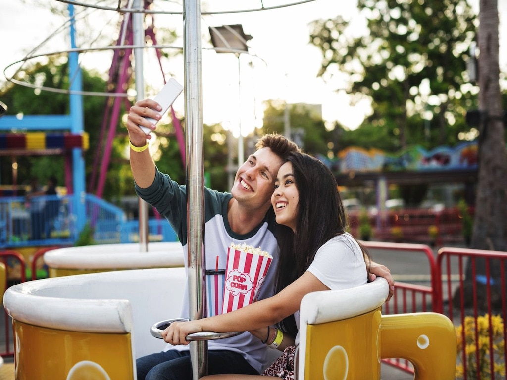 girl and girl at fairground looking at phone