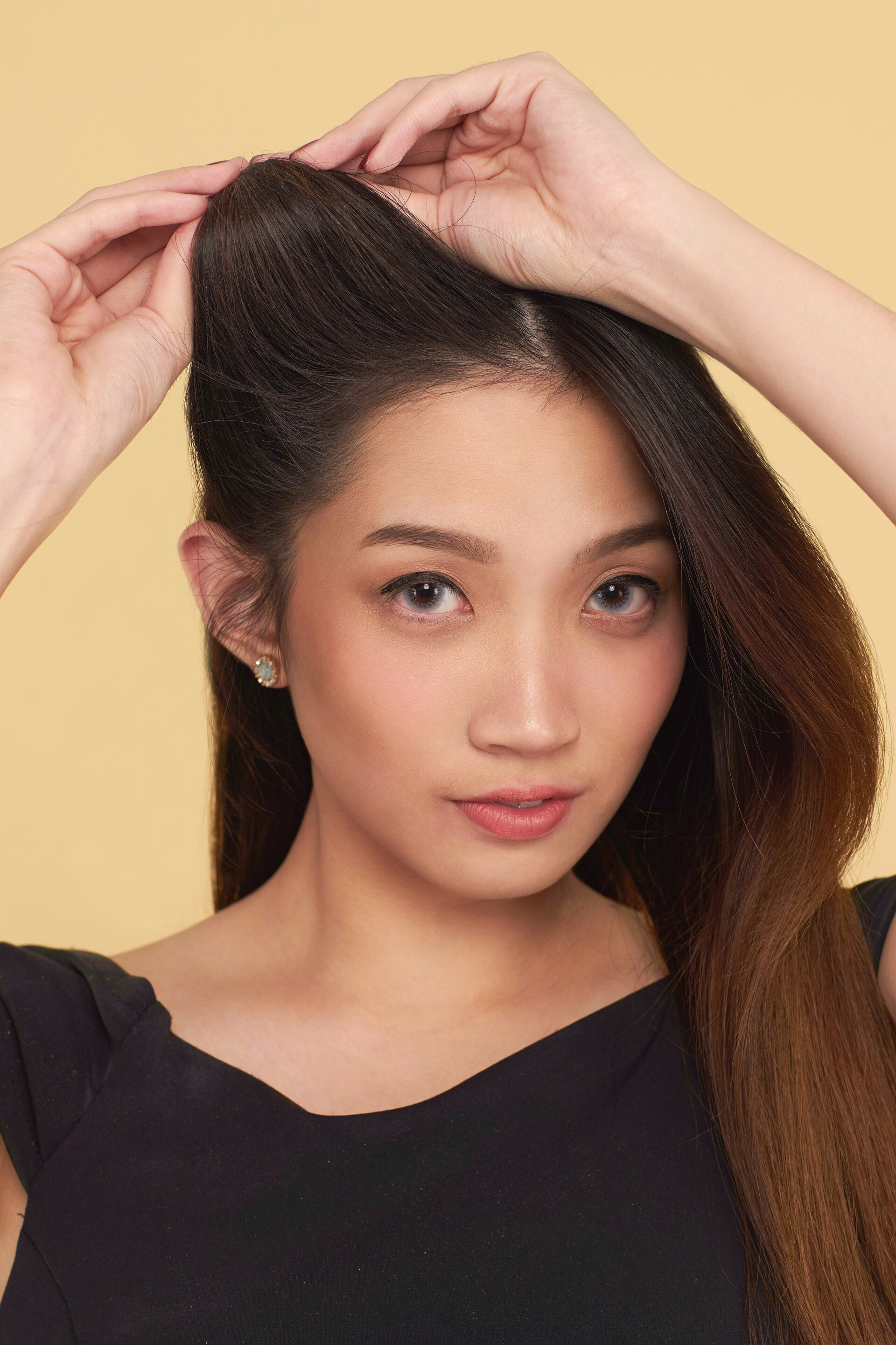 Wanita asia dengan rambut panjang sedang menggulung rambut.