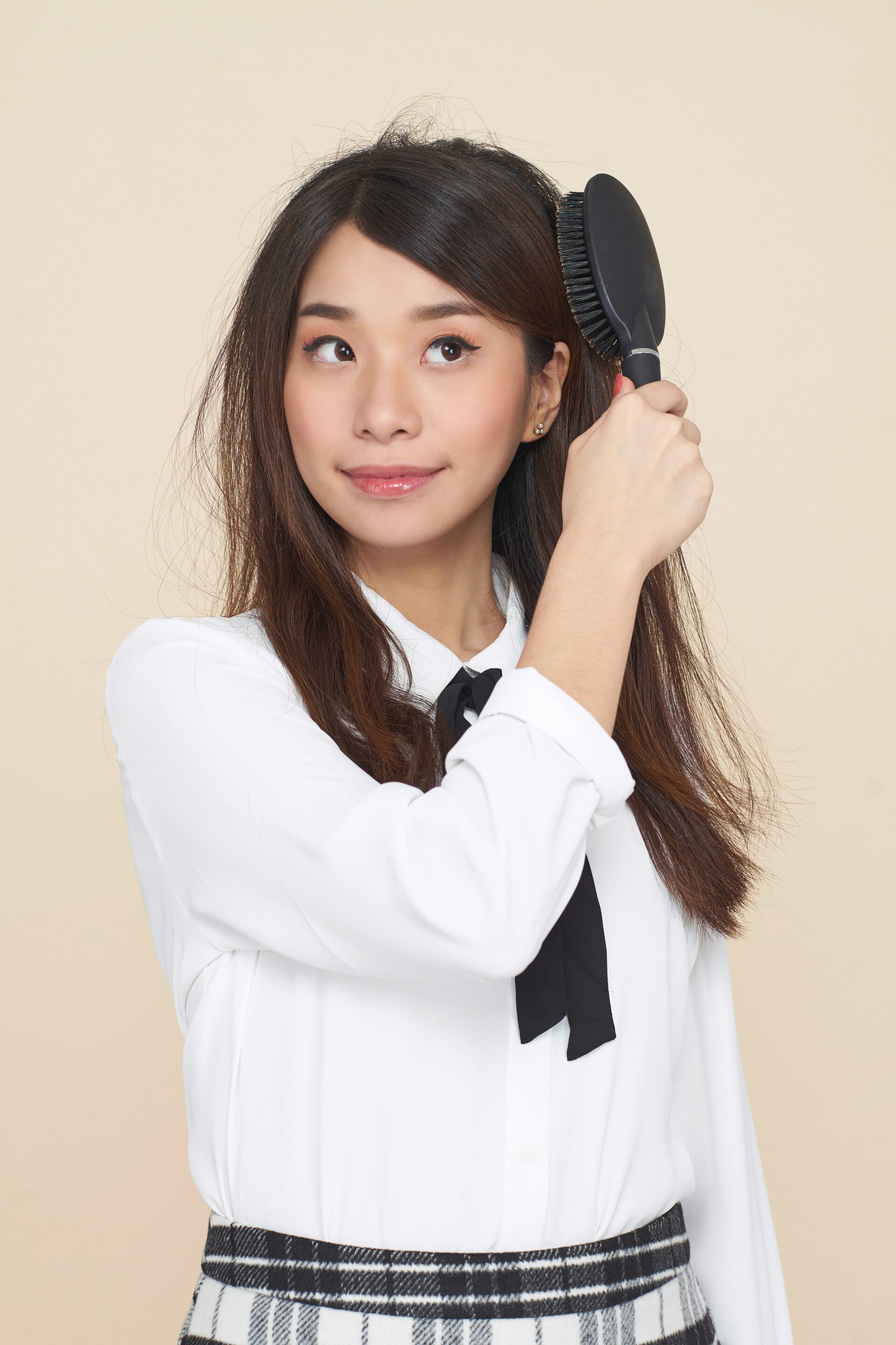 Wanita asia dengan rambut panjang menyisir rambut.