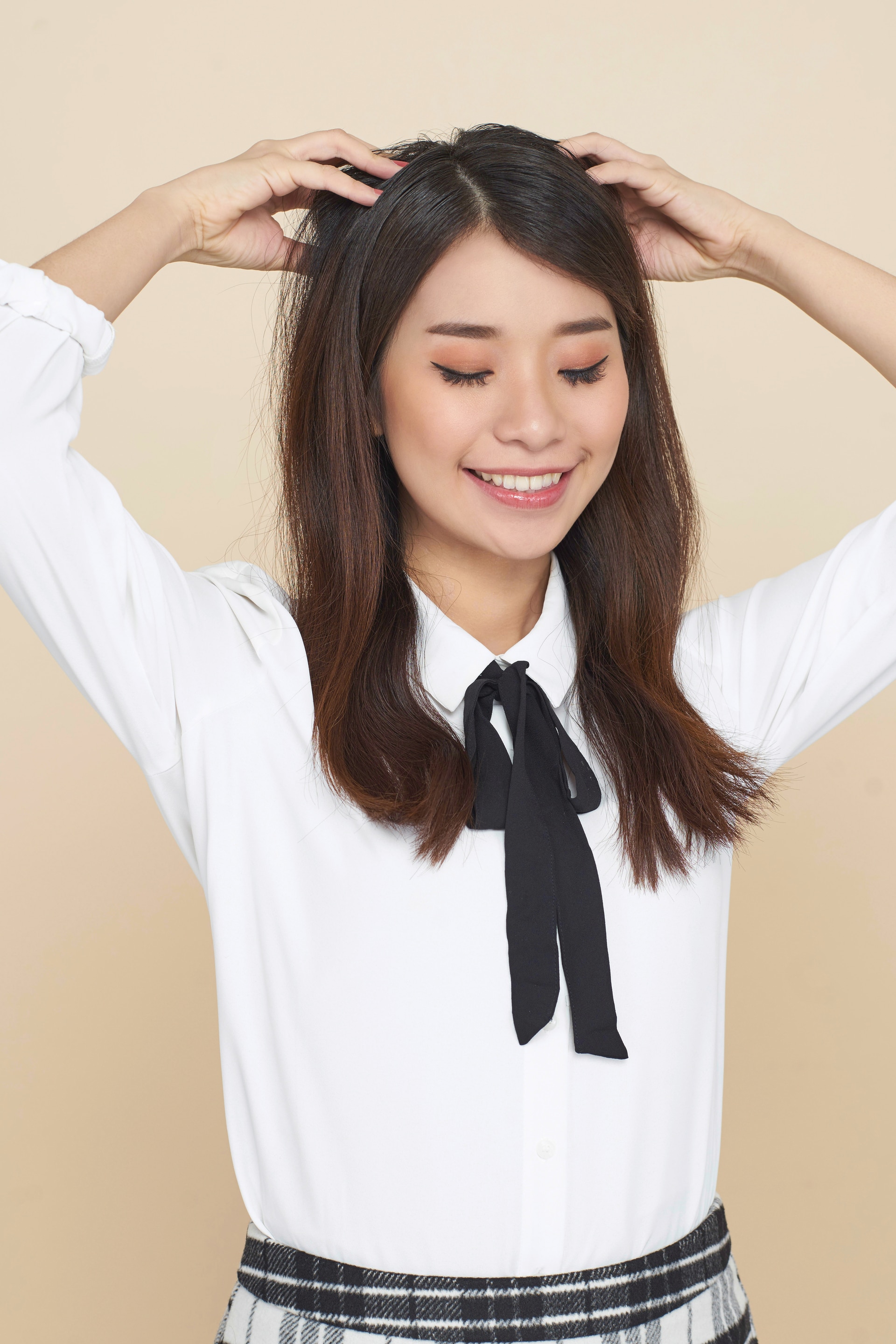 Wanita asia dengan rambut panjang menggaruk rambut.