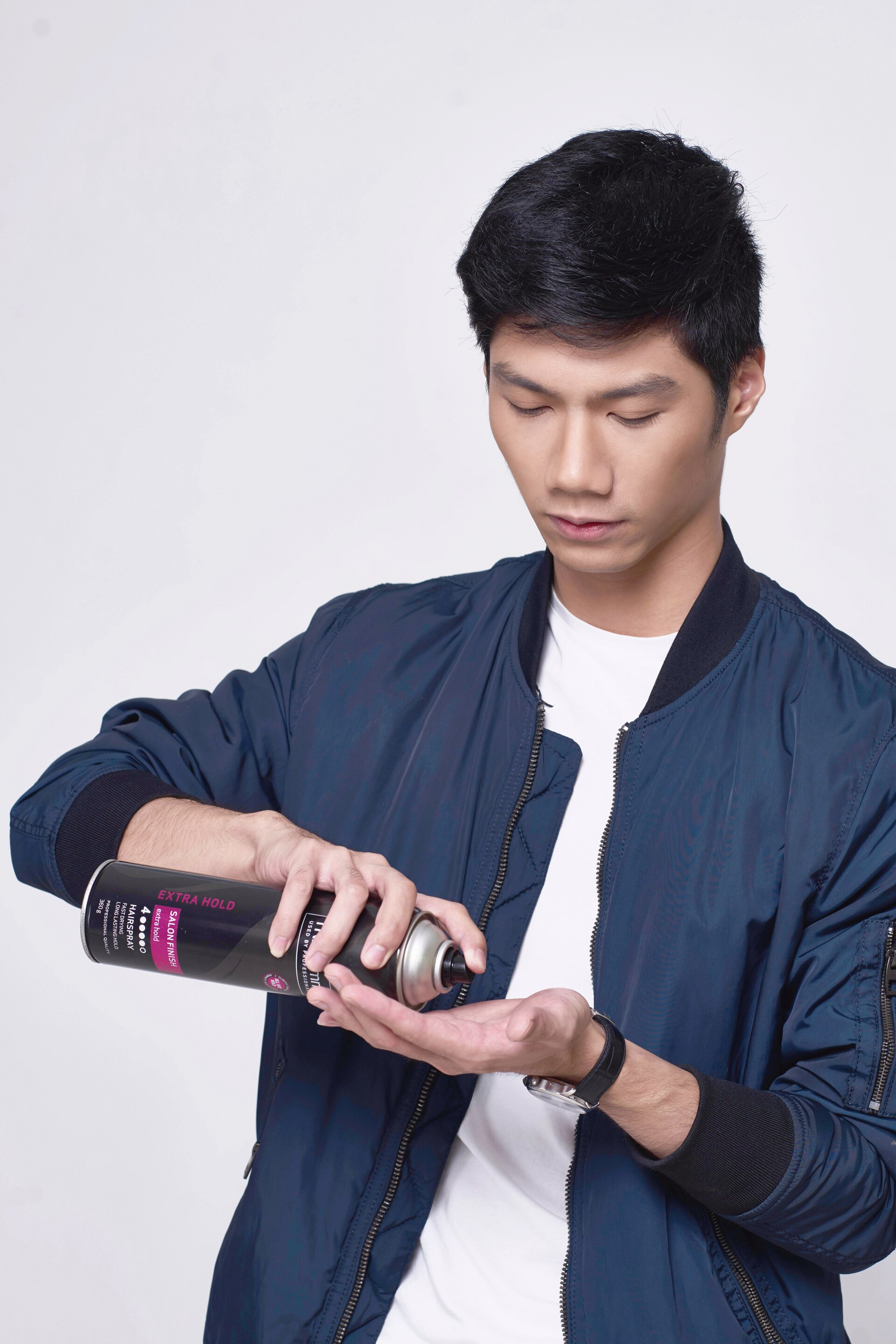 Pria Asia memakai hairspray di telapak tangan