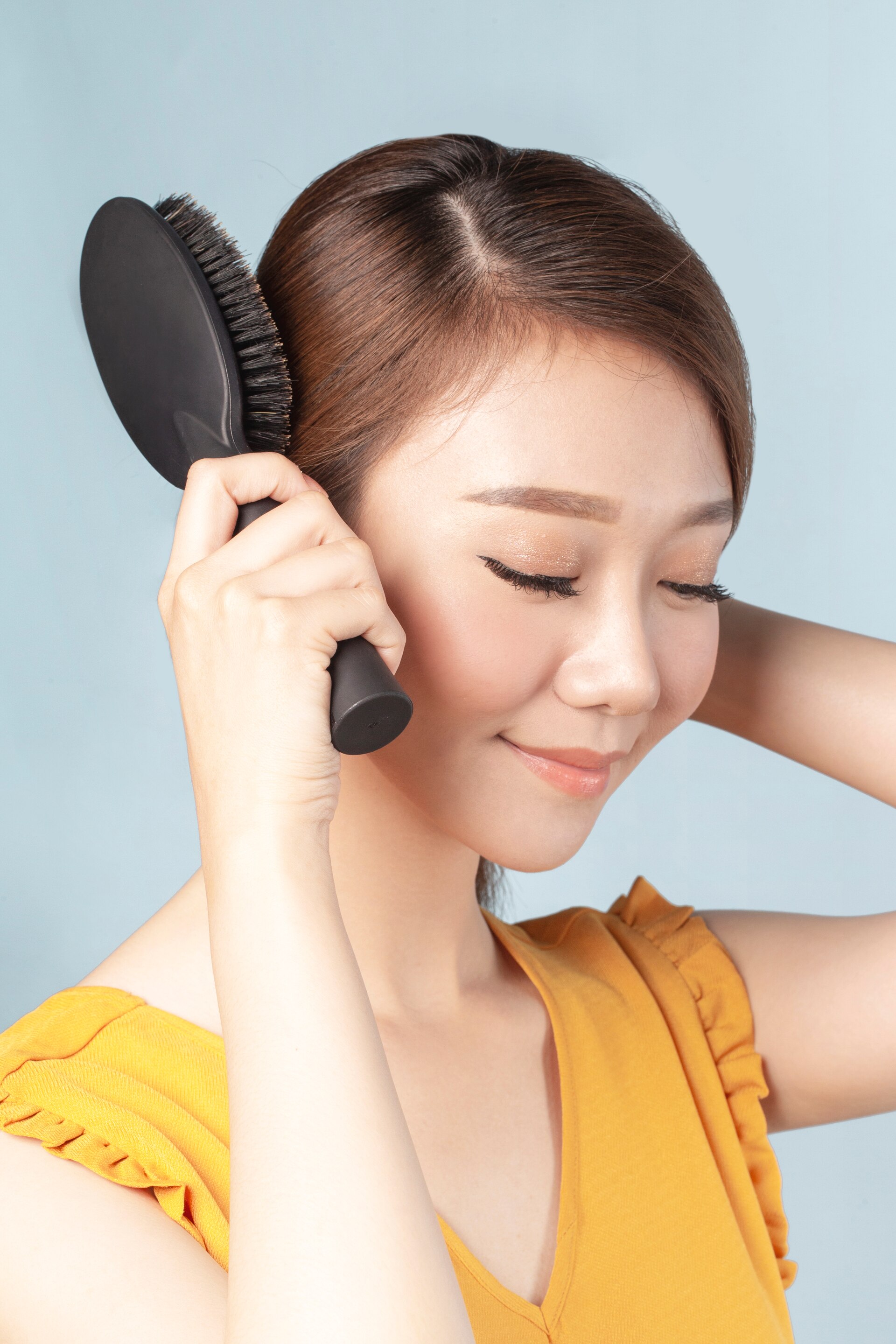 Wanita cantik sedang menyisir rambut