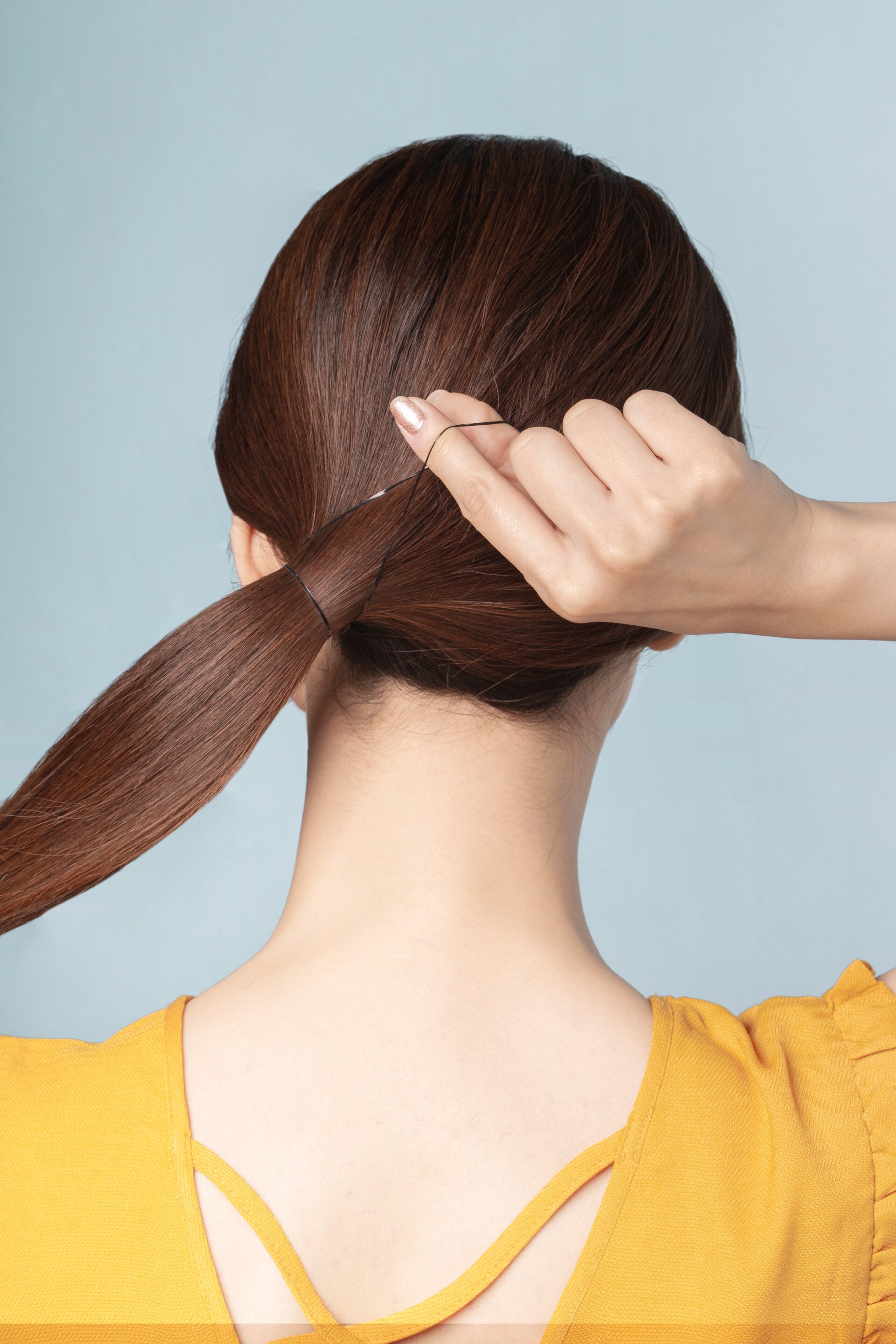 Wanita sedang mengikat rambut