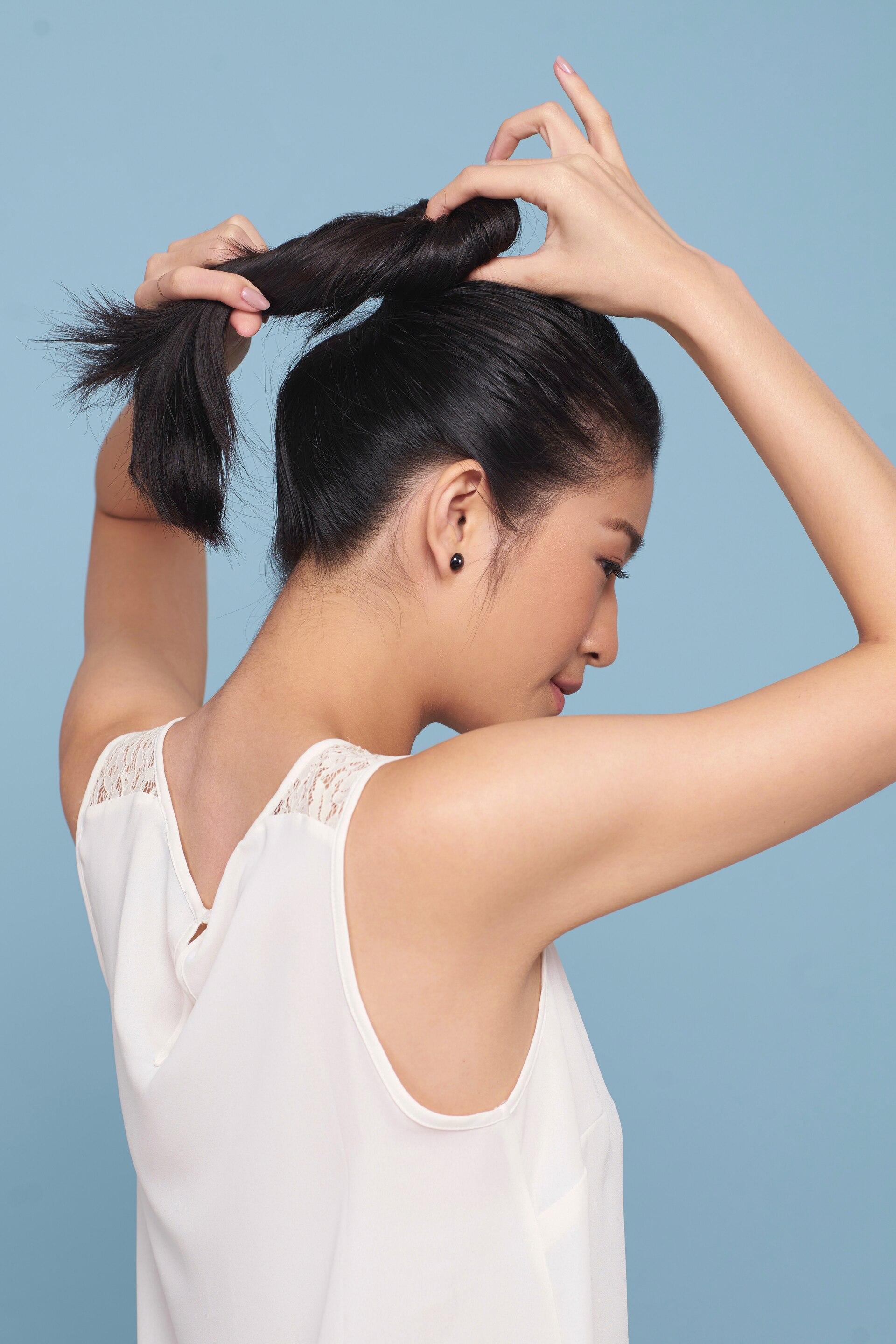 Wanita asia membentuk ponytail untuk gaya french braid bun warna rambut hitam