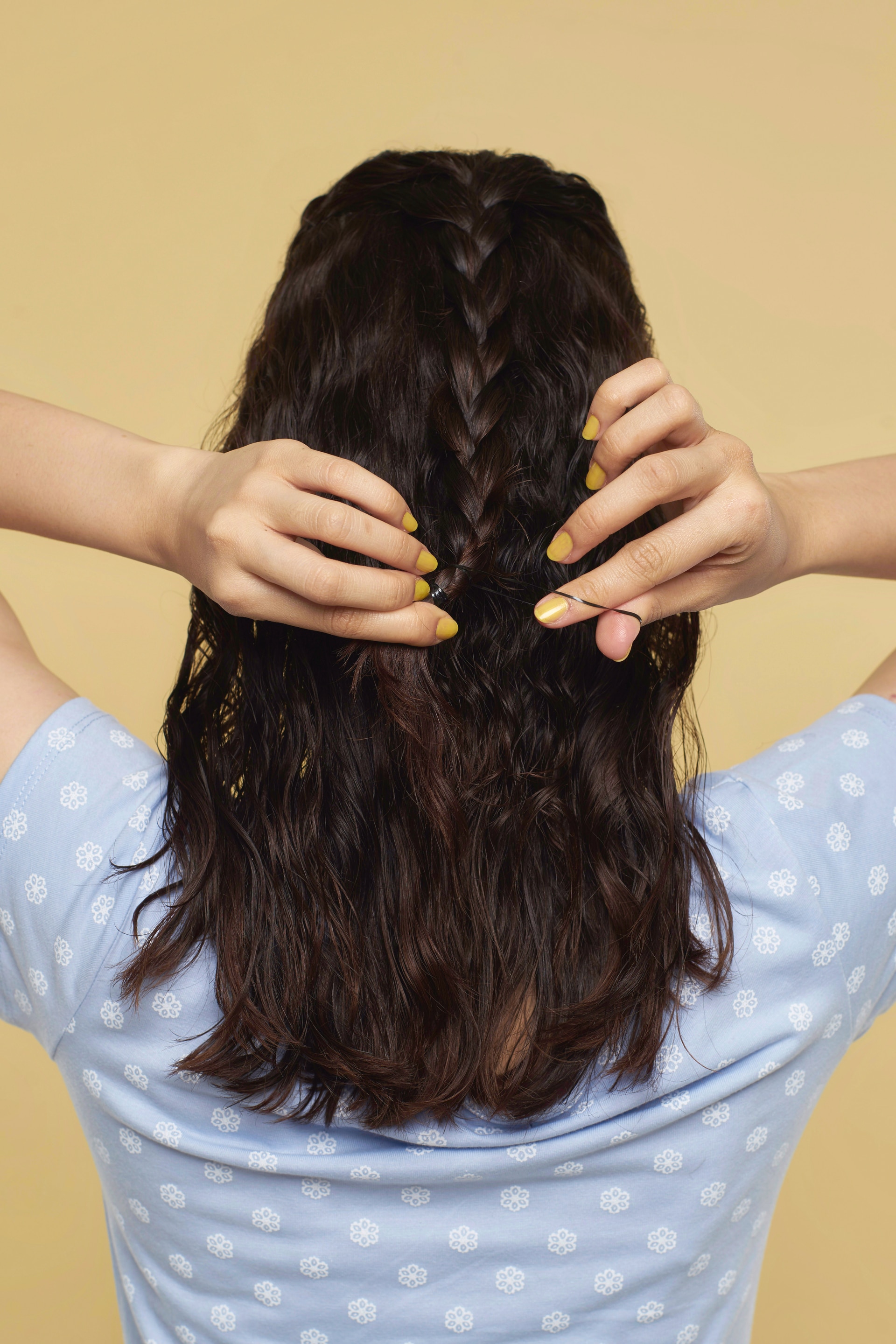 Wanita asia dengan rambut cokelat keriting dengan model rambut mermaid braid