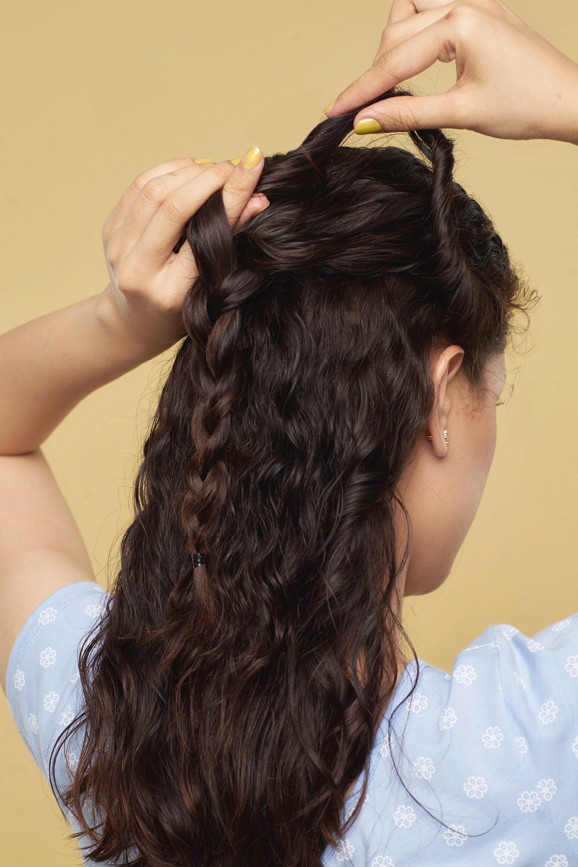 Wanita asia dengan rambut cokelat gelap mengepang jalinan rambut mermaid braid