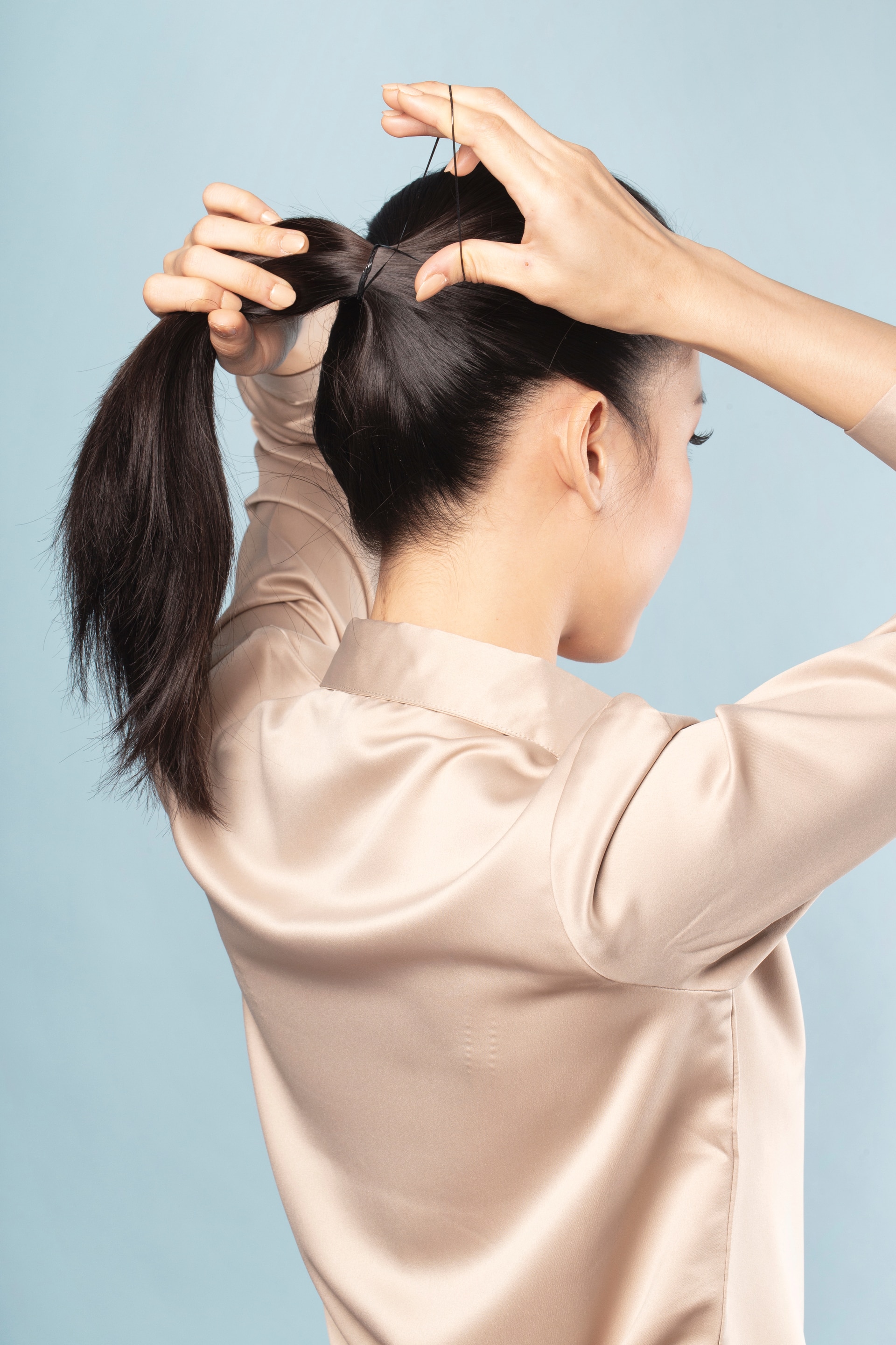 Wanita asia menata rambut dalam bentuk ponytail