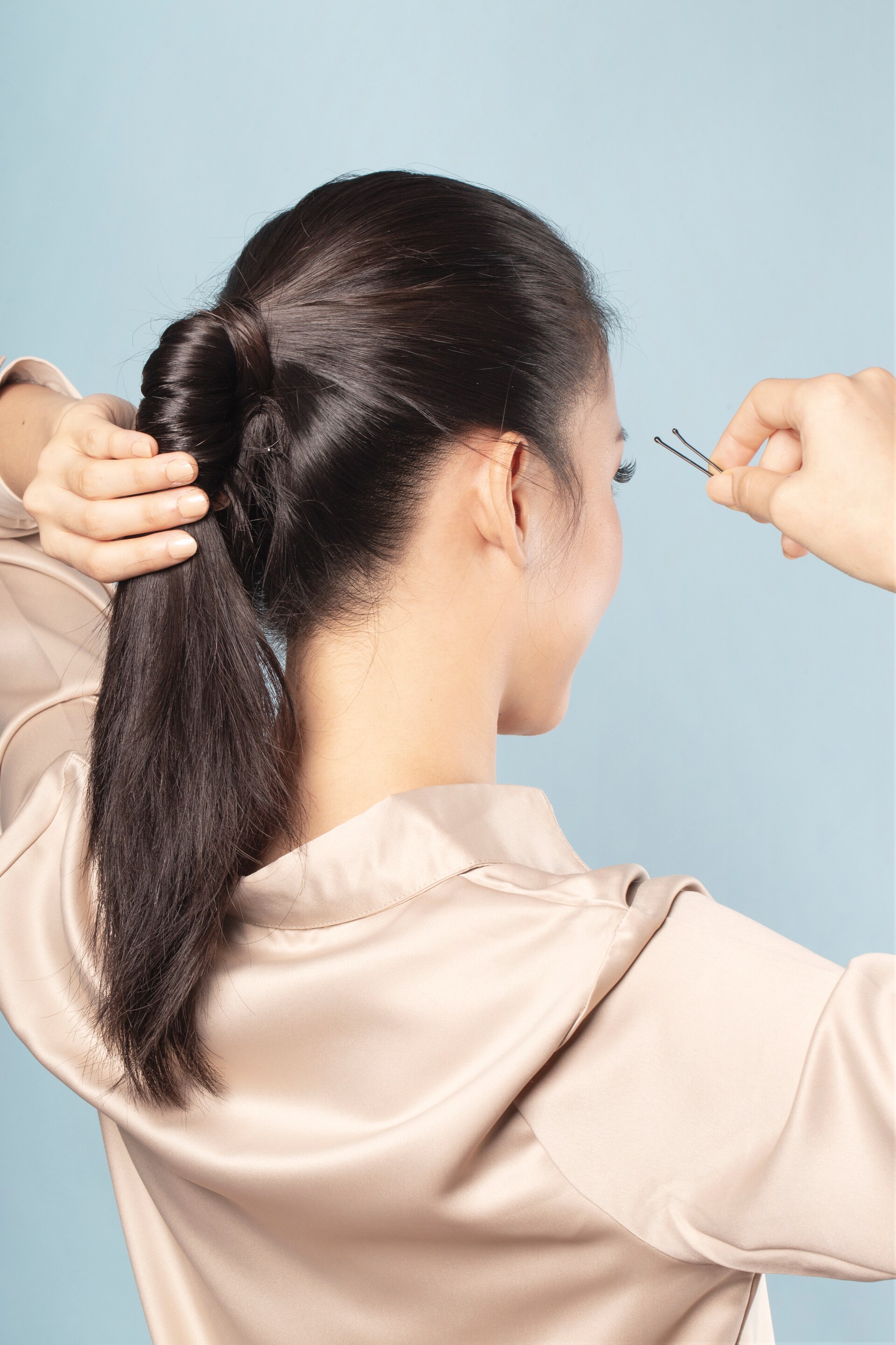 Wanita asia sedang menata ponytail