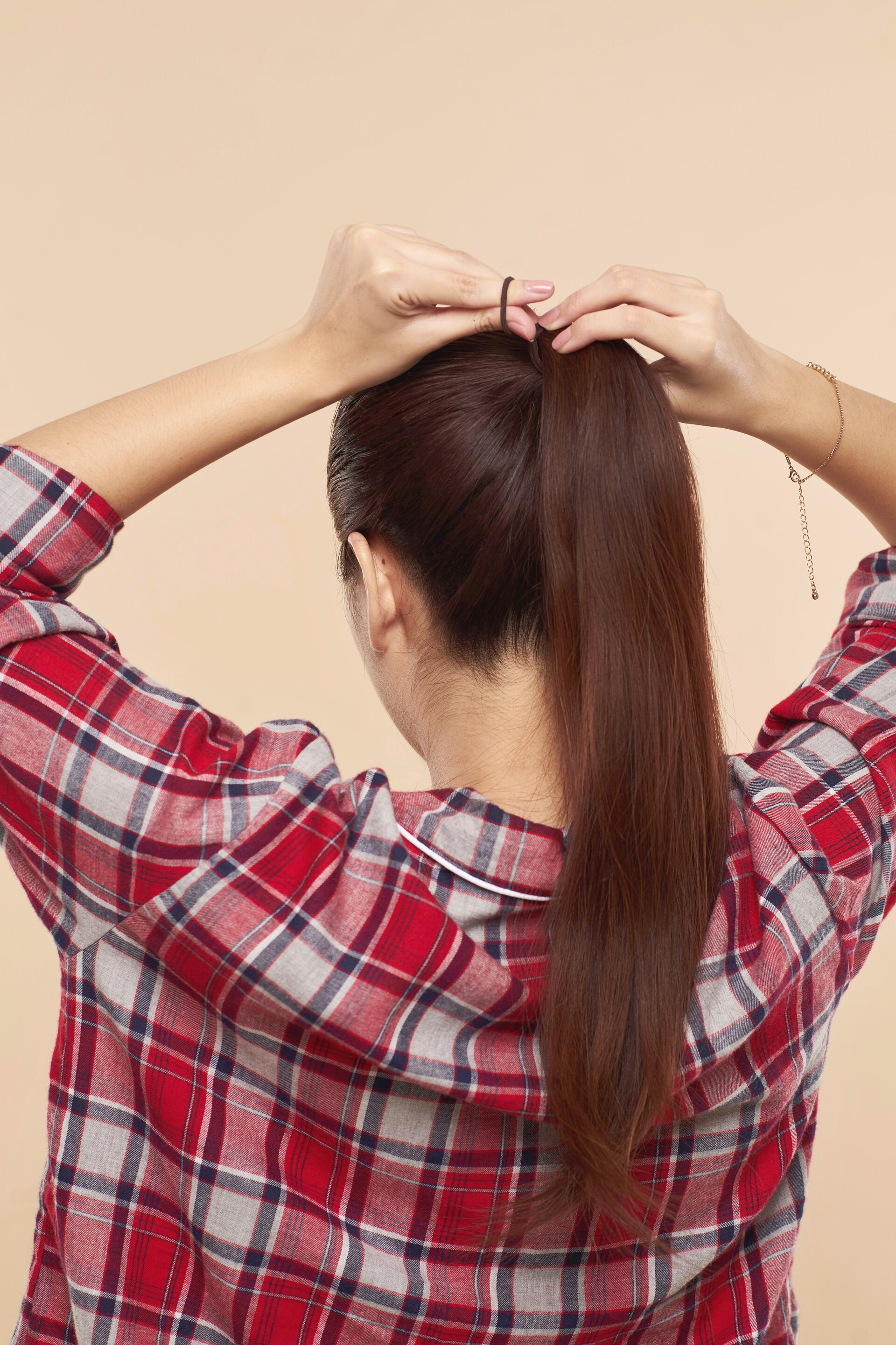 Wanita asia sedang membuat ponytail - menata rambut gaya cepol panjang