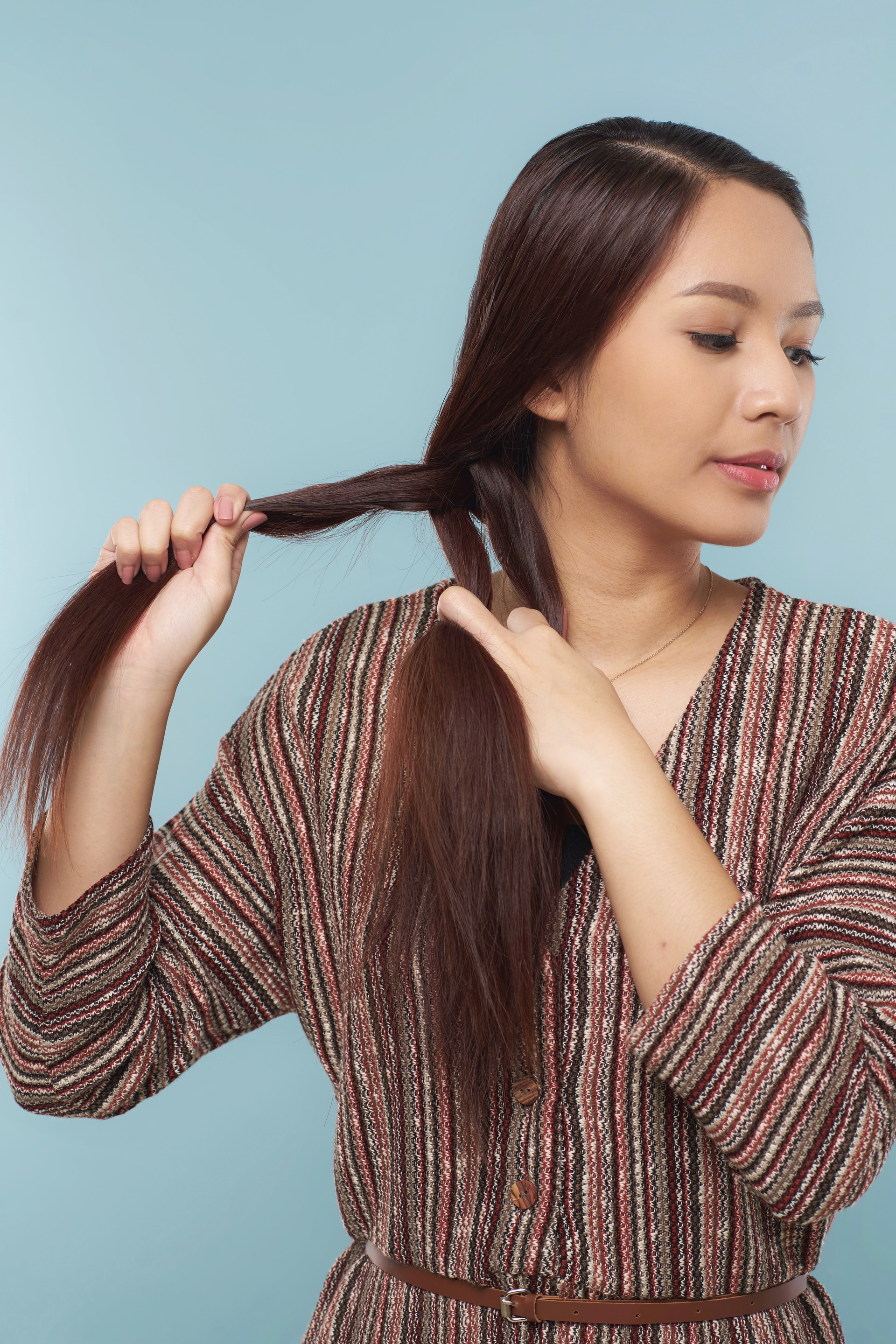 Wanita asia dengan model kepang meneruskan mengepang rambut