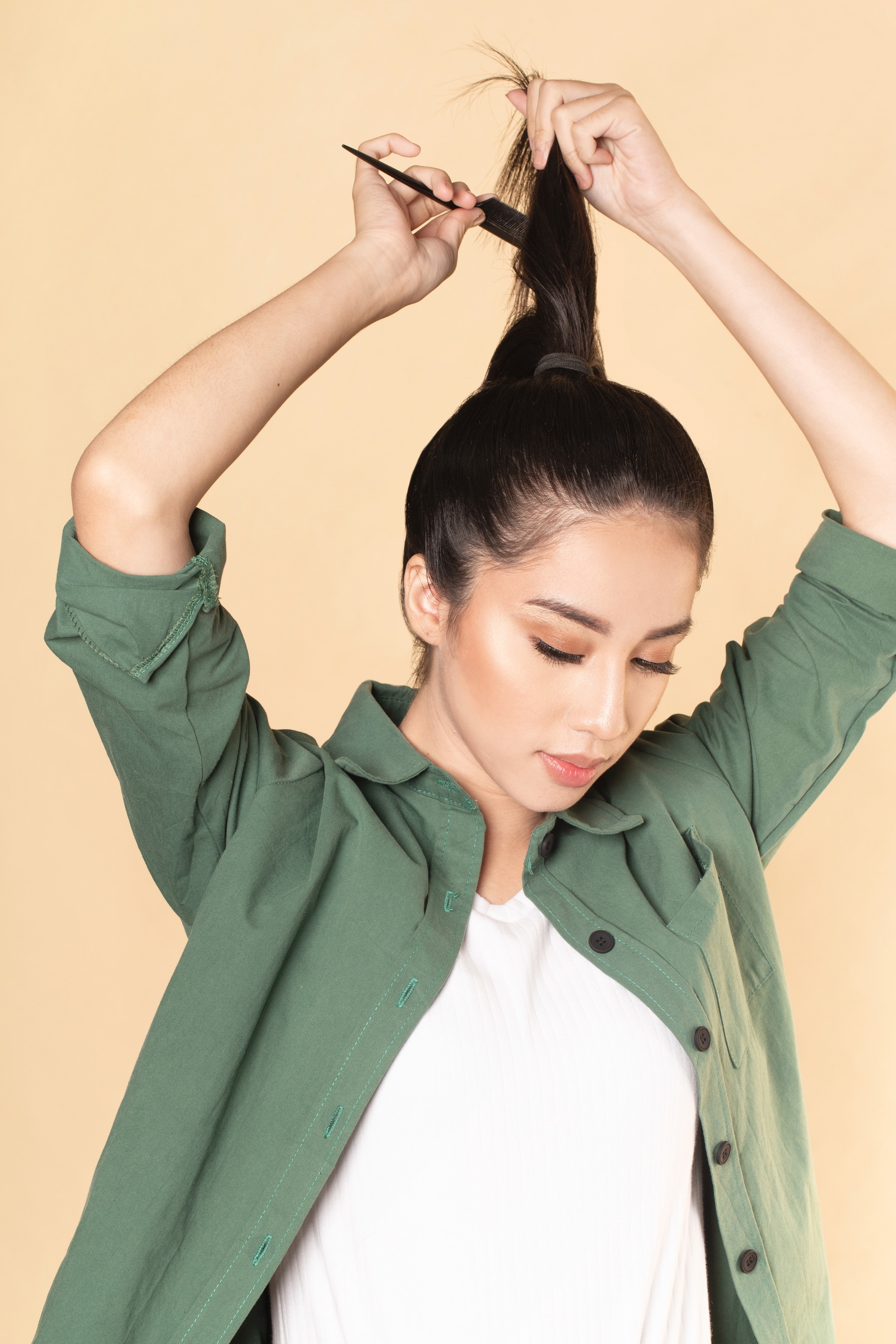 Wanita asia dengan rambut hitam menyasak rambut