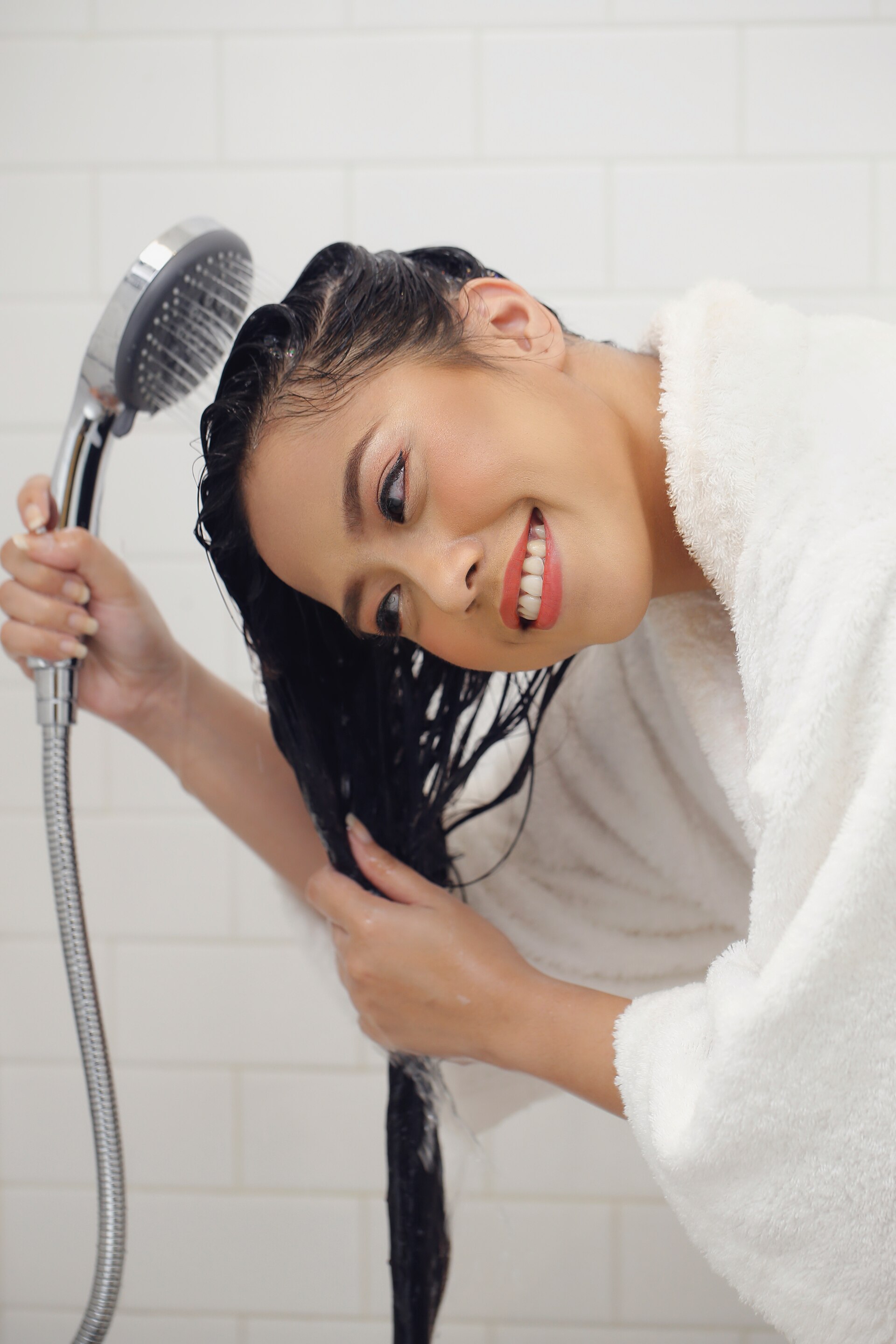 Wanita asia membilas rambut untuk Keramas tanpa shampoo