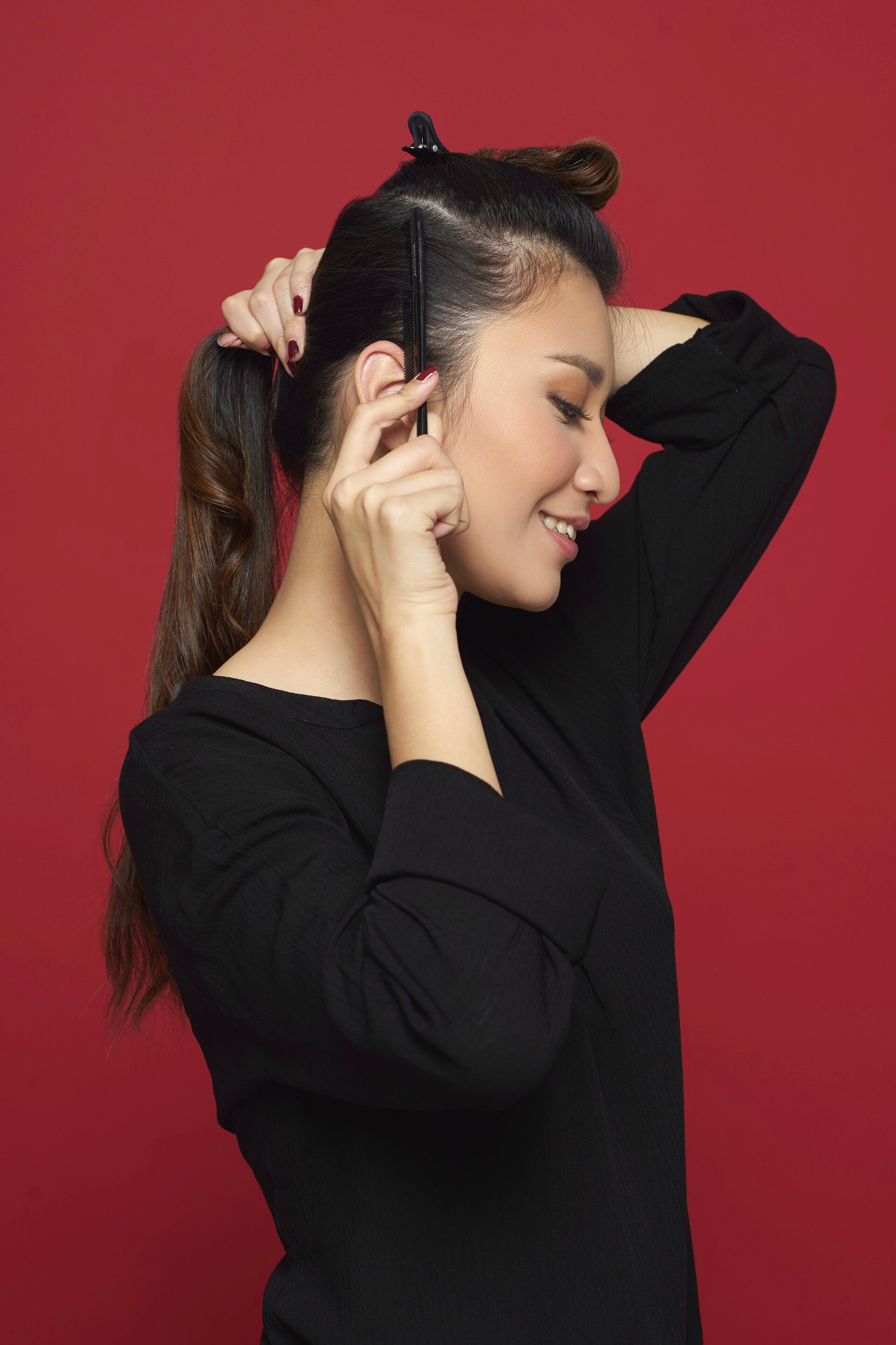 Wanita asia membagi rambutnya dengan jepit rambut.