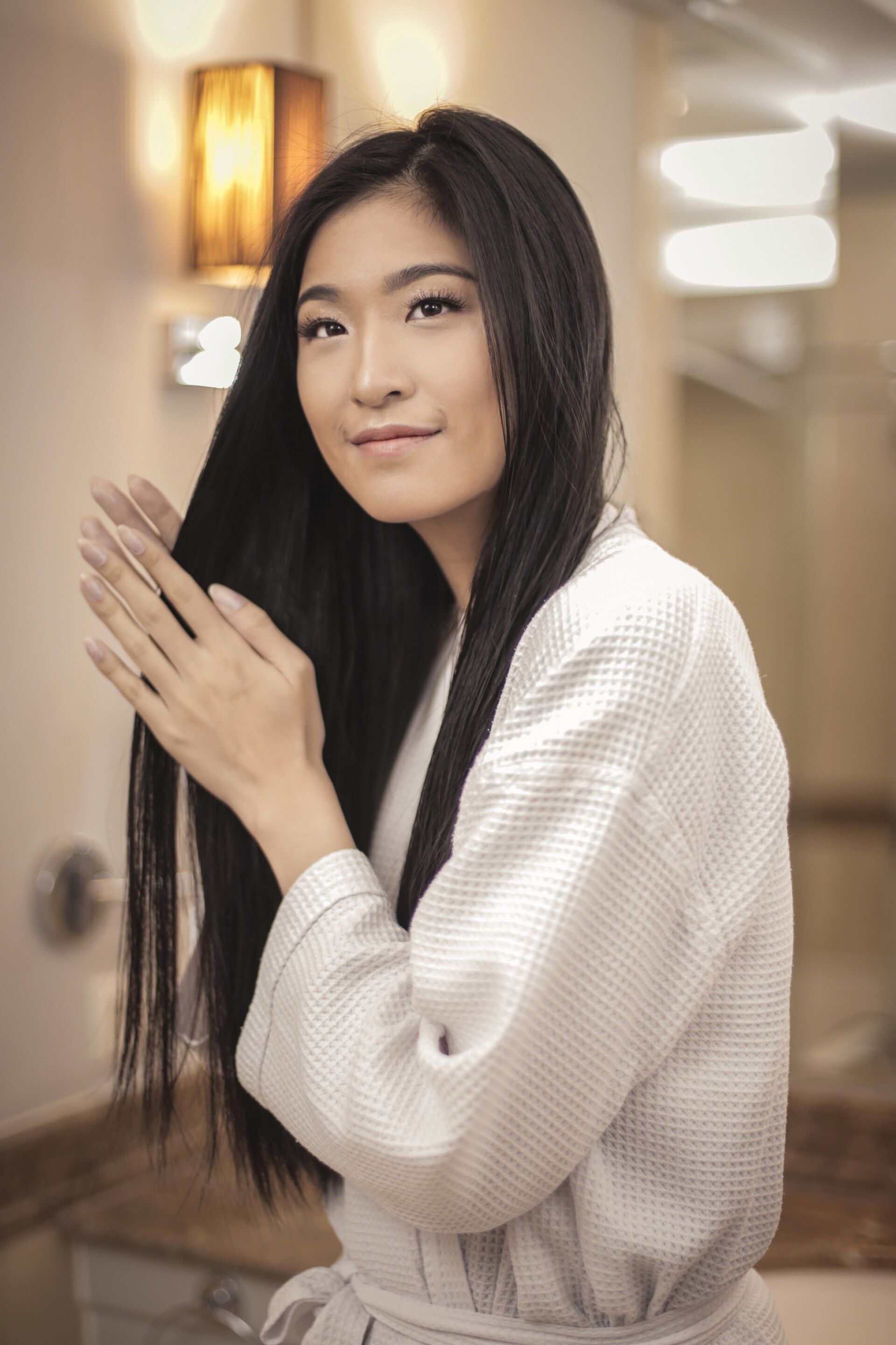 Wanita asia menggunakan conditioner pada rambut