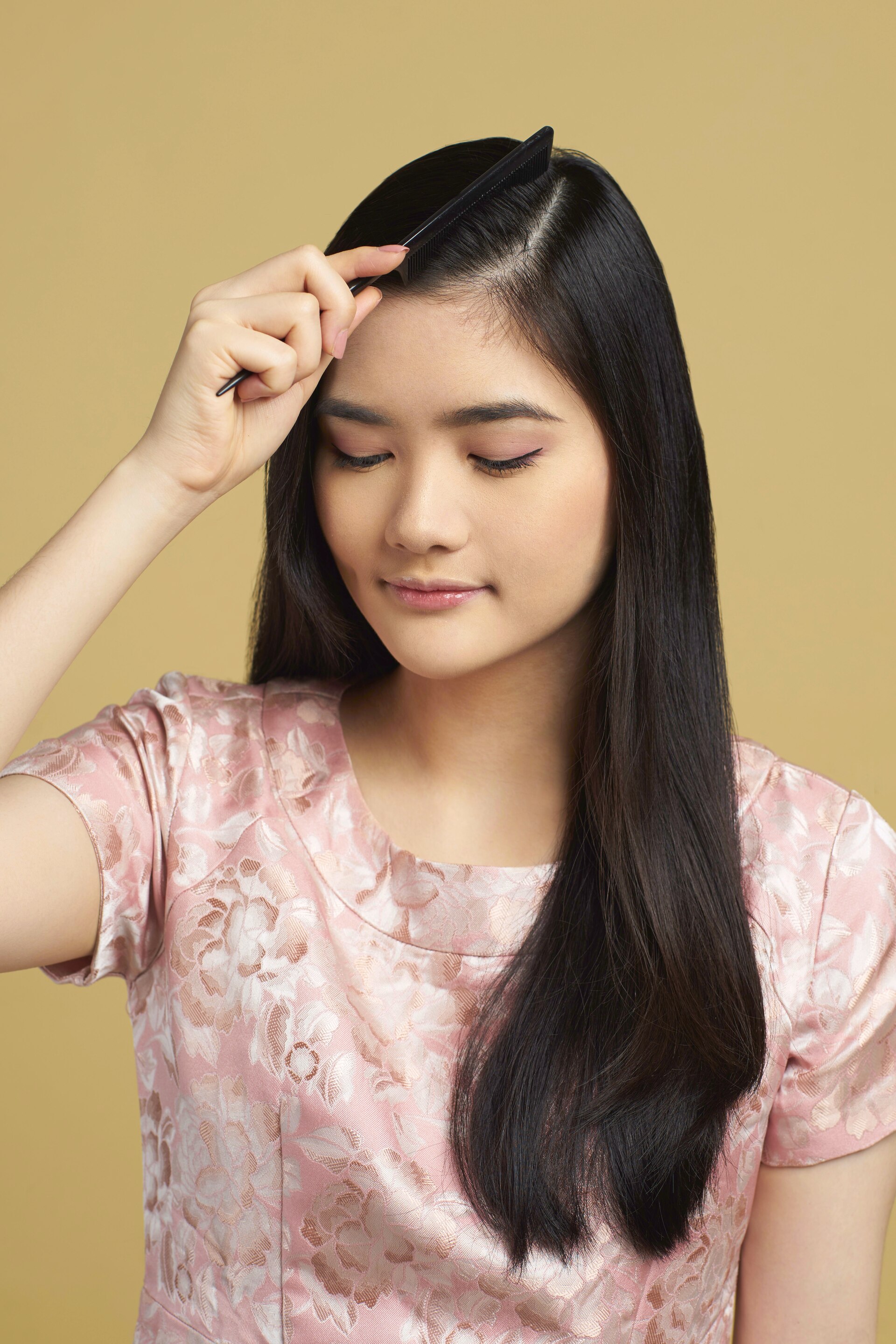 Wanita asia dengan model rambut hitam panjang membelah samping rambut - side part sleek low bun