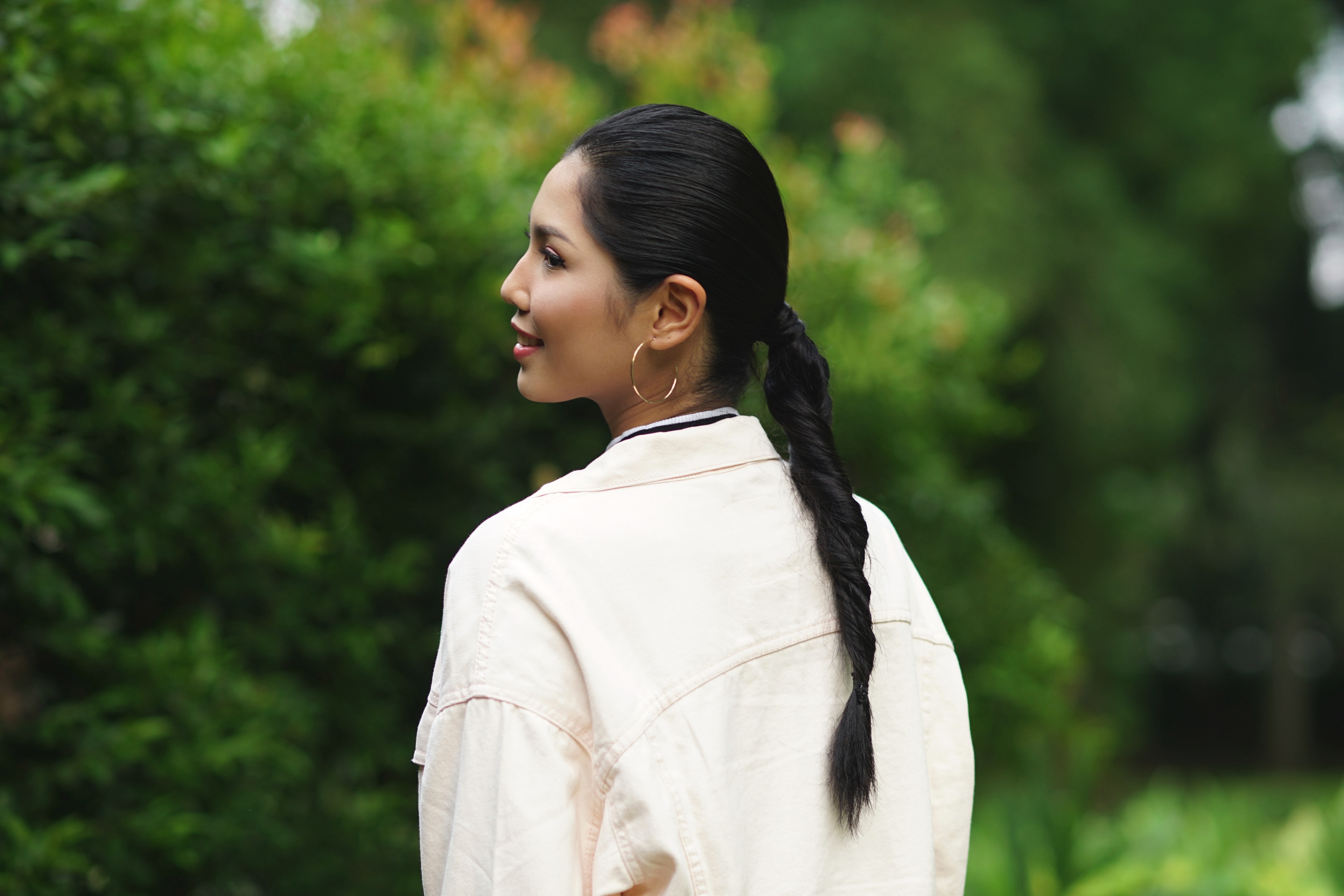 Wanita asia dengan rambut hitam panjang menggunakan gaya rambut double rope braid ponytail