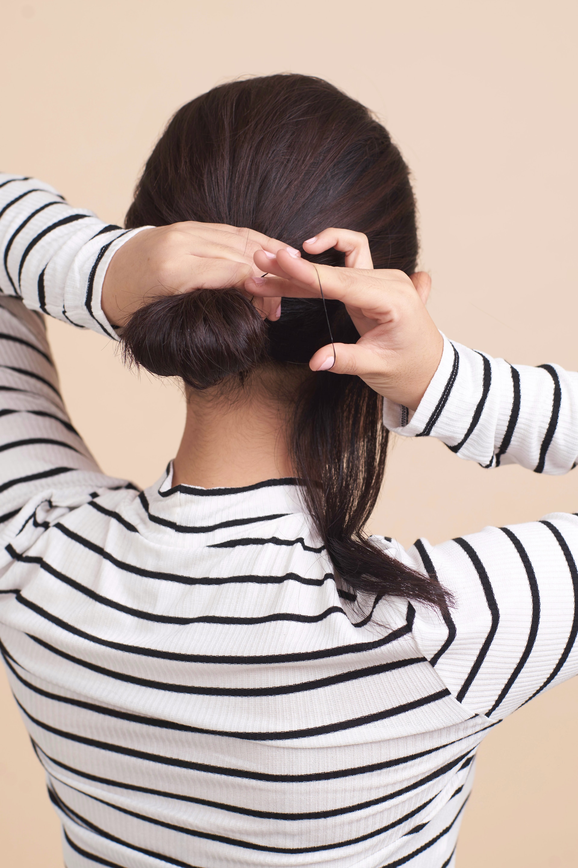 Wanita asia dengan rambut pendek menata cepol - cepol rambut pendek