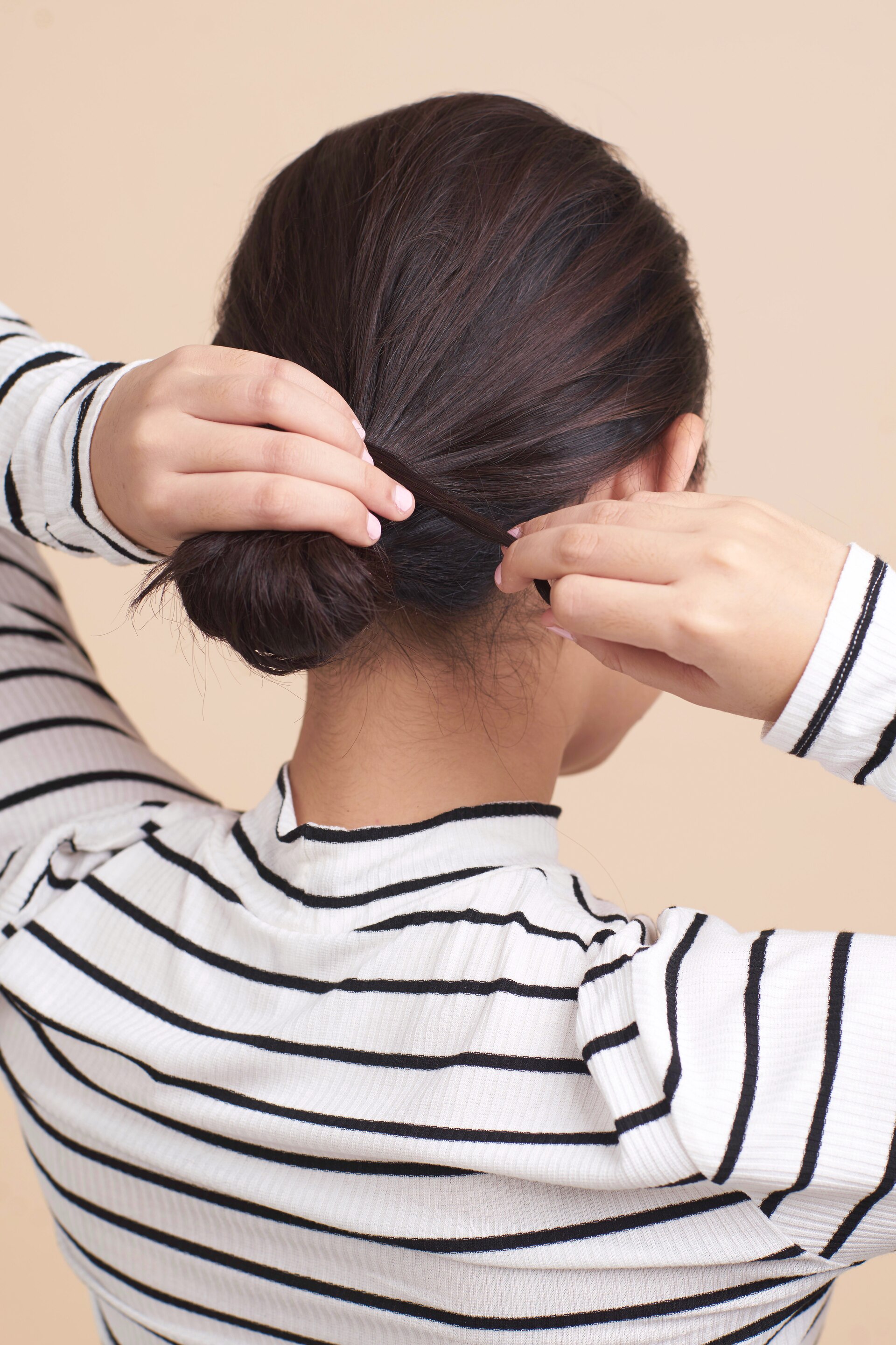 Wanita asia dengan rambut pendek melingkarkan rambut pada cepol - cepol rambut pendek