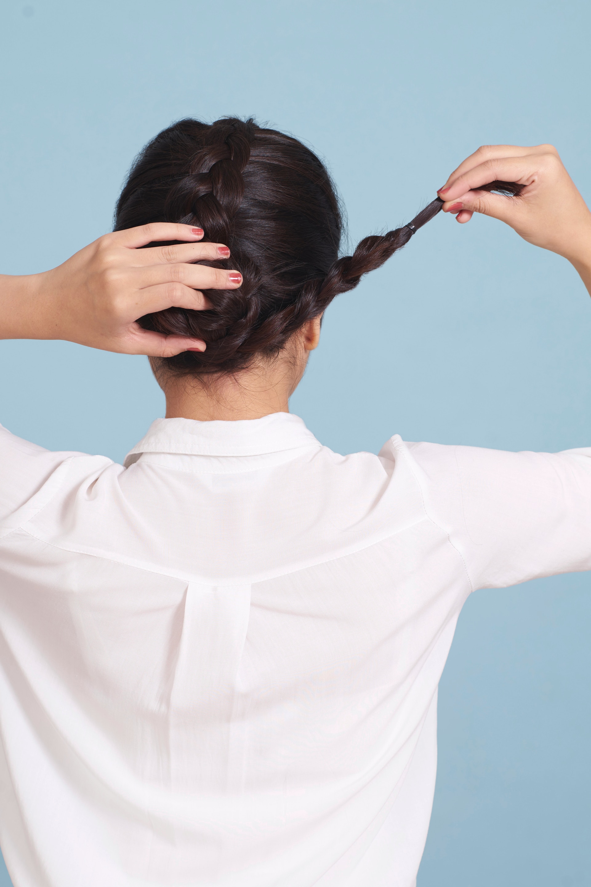 wanita asia sedang membuat sanggul kepang gaya messy