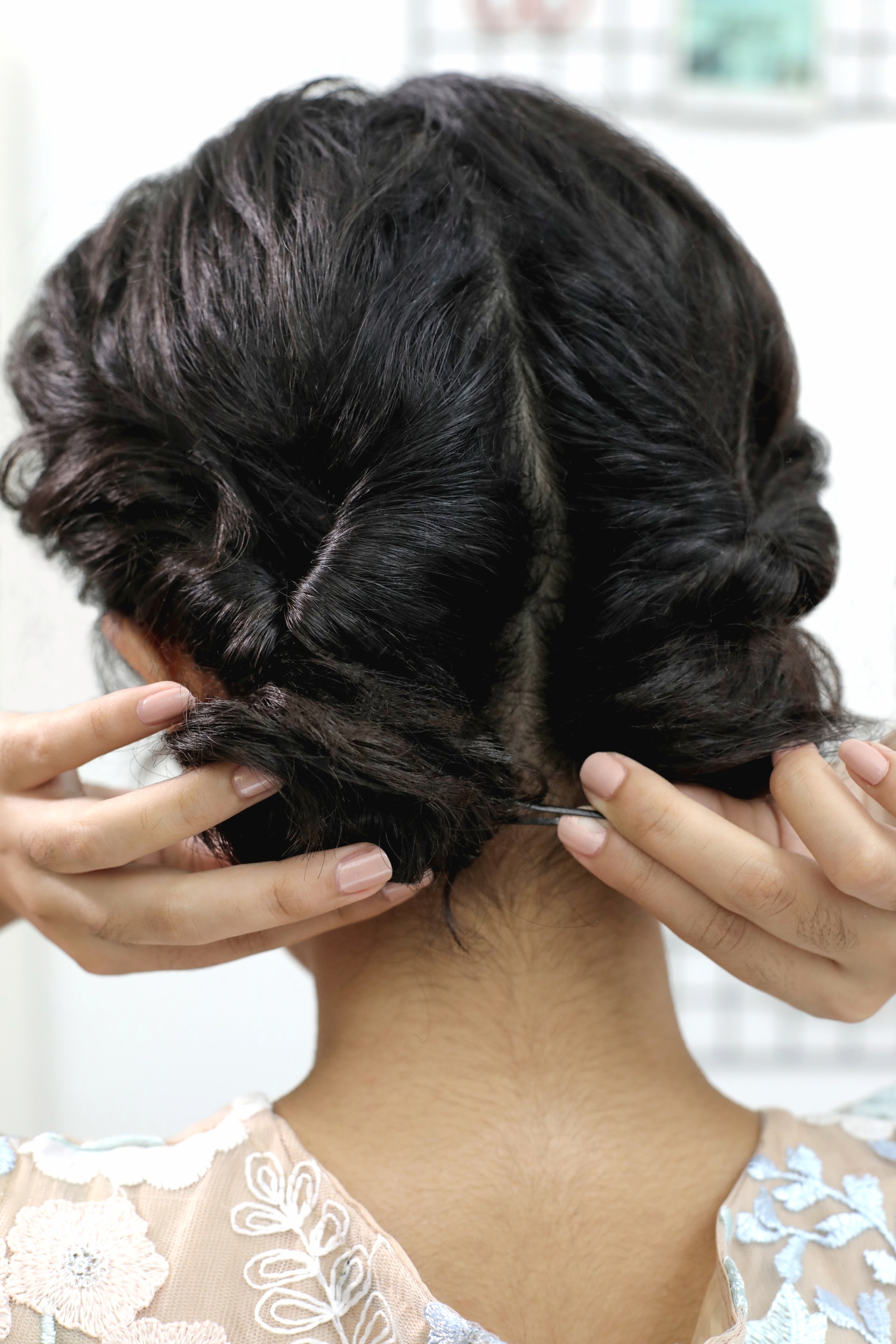 Wanita Asia sedang menjepit rambut yang dicepol