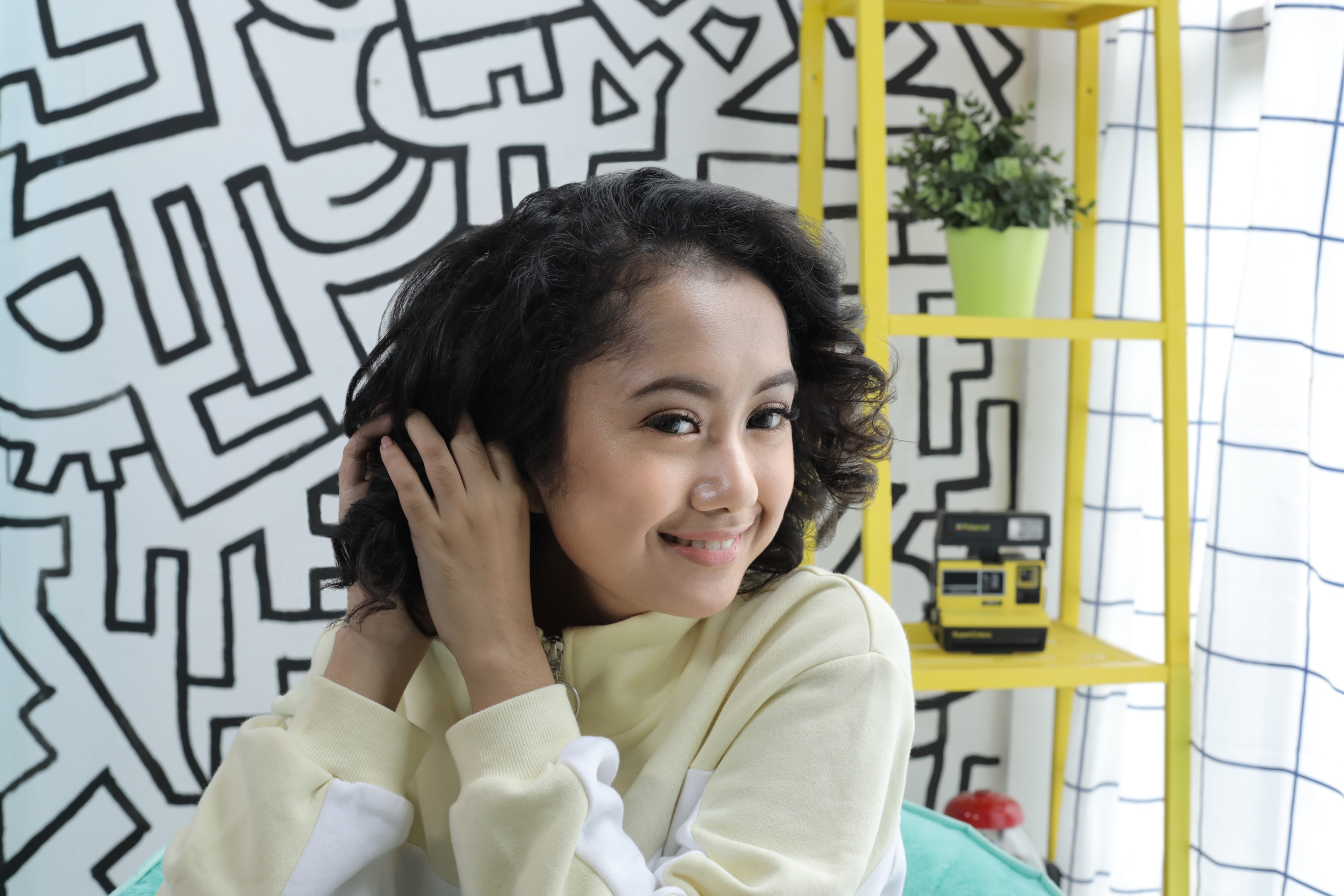 wanita asia berambut keriting sedang mengoleskan vitamin rambut