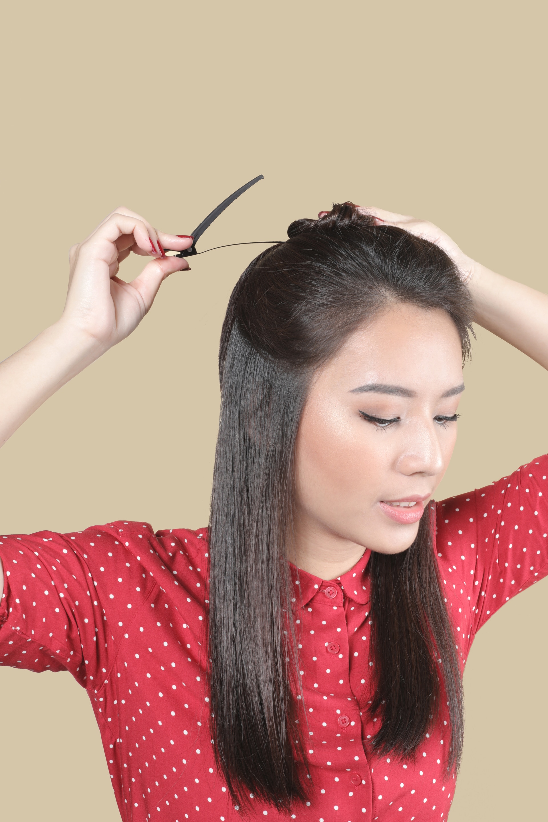 Wanita Asia sedang menjepit rambut bagian atas