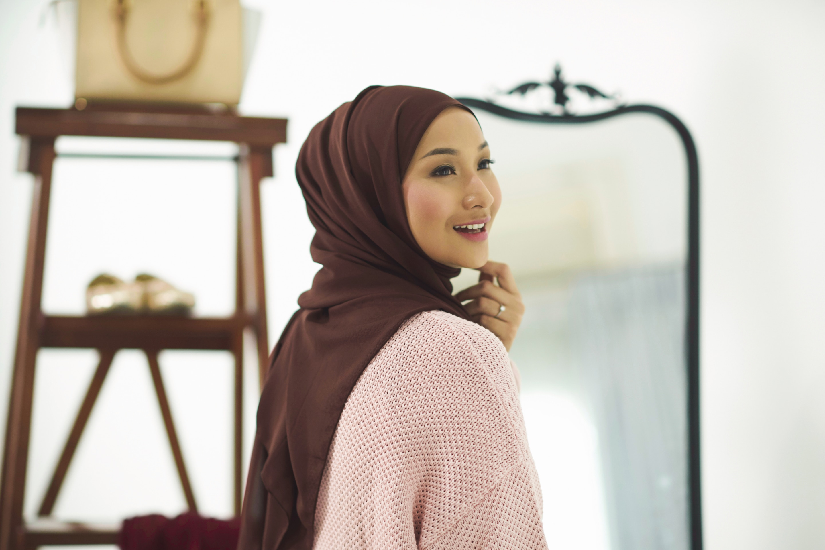 Wanita asia dengan hijab warna maroon dan sweater pink dalam gaya hijab arab