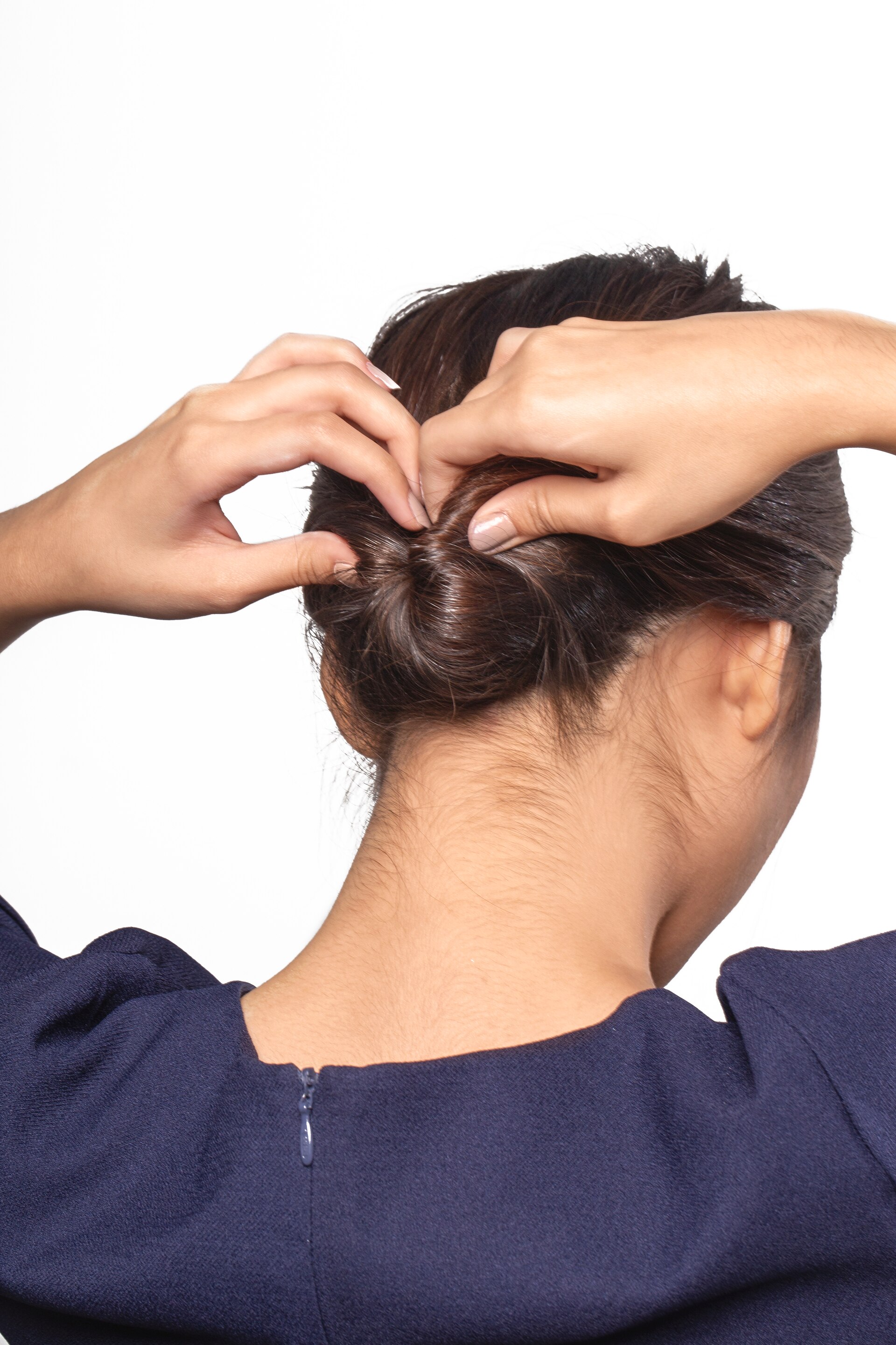 wanita asia sedang membuat twist untuk sanggul chignon