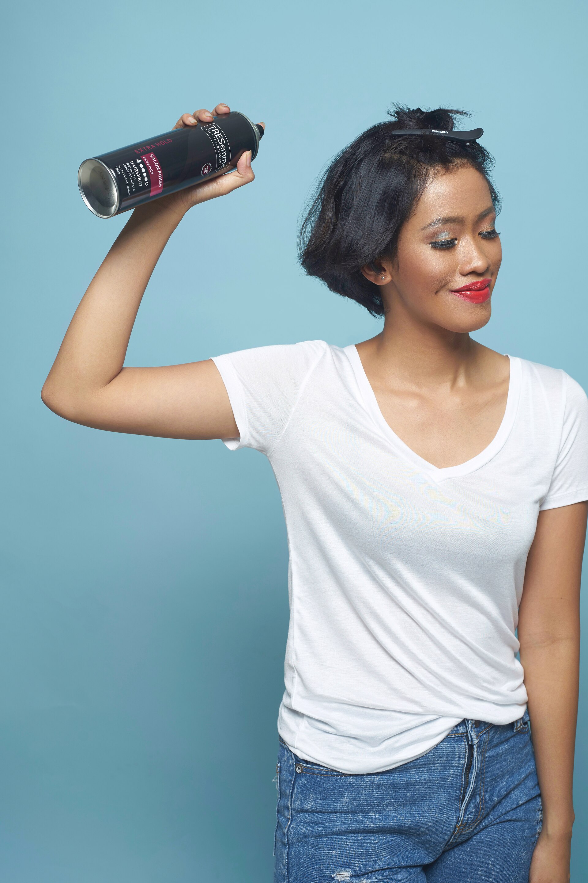 Wanita asia dengan rambut pendek warna hitam menggunakan hairspray