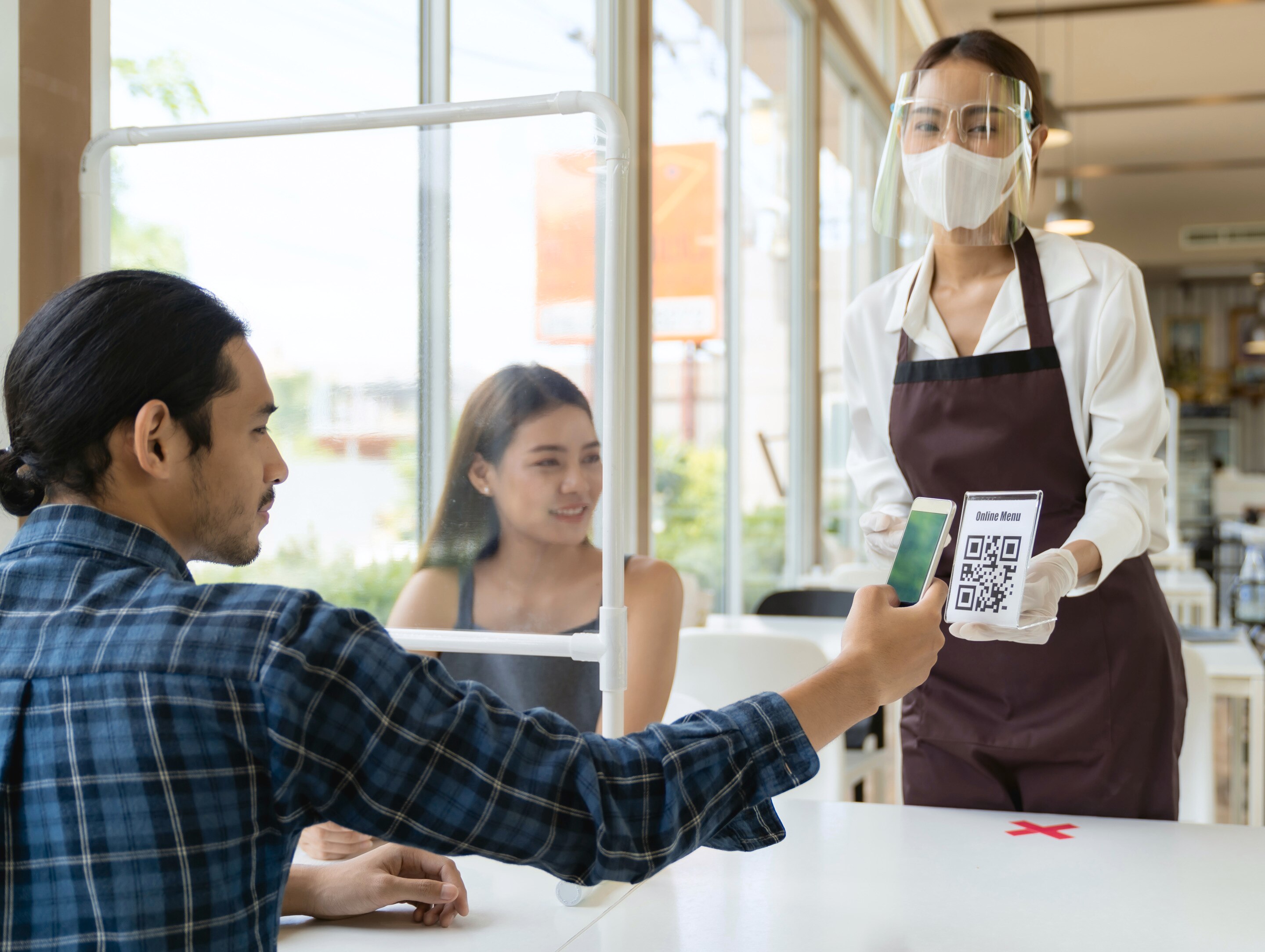 pria sedang memilih menu di restoran yang menerapkan protokol kesehatan