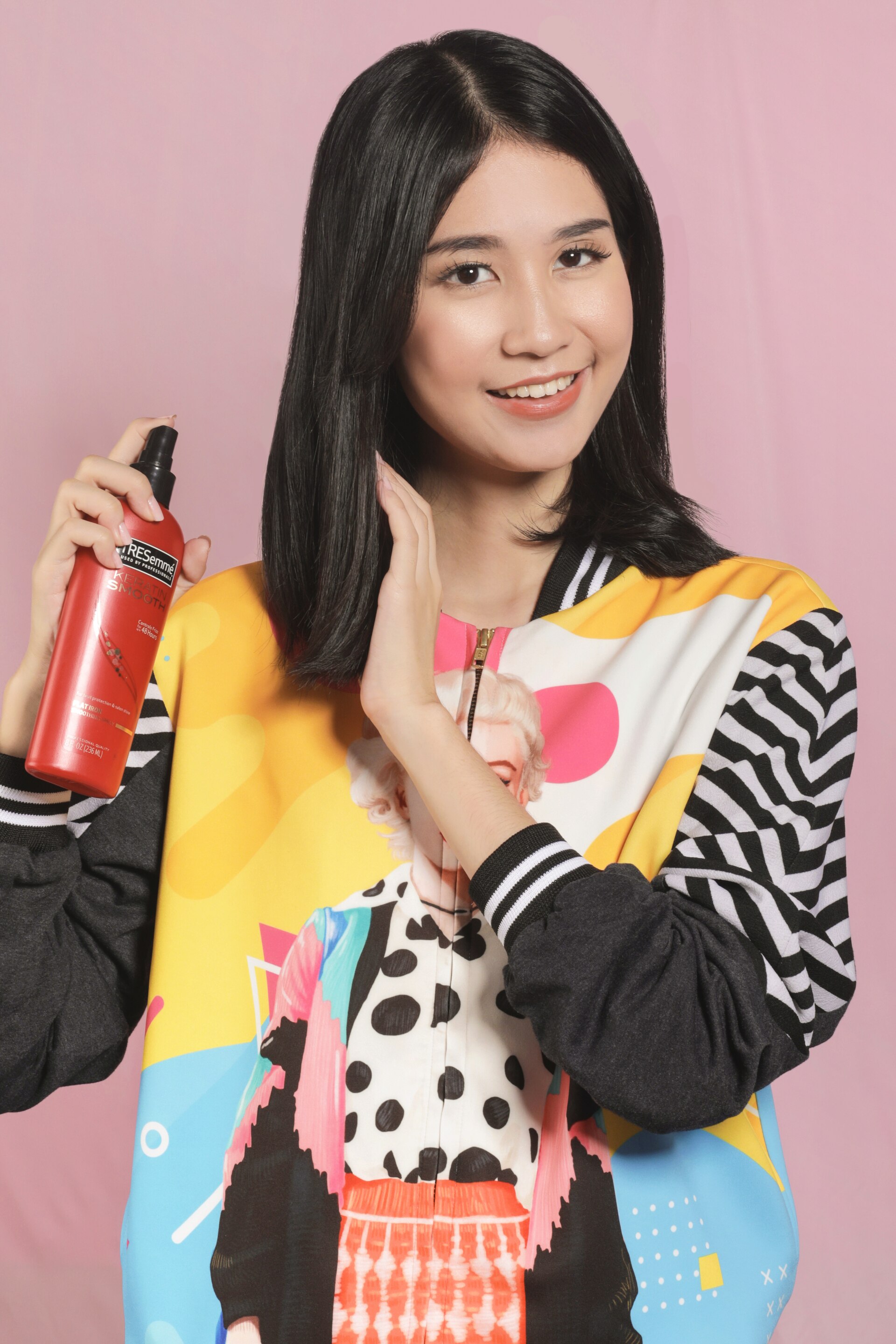 wanita asia berambut hitam pendek menyemprot heat protection spray