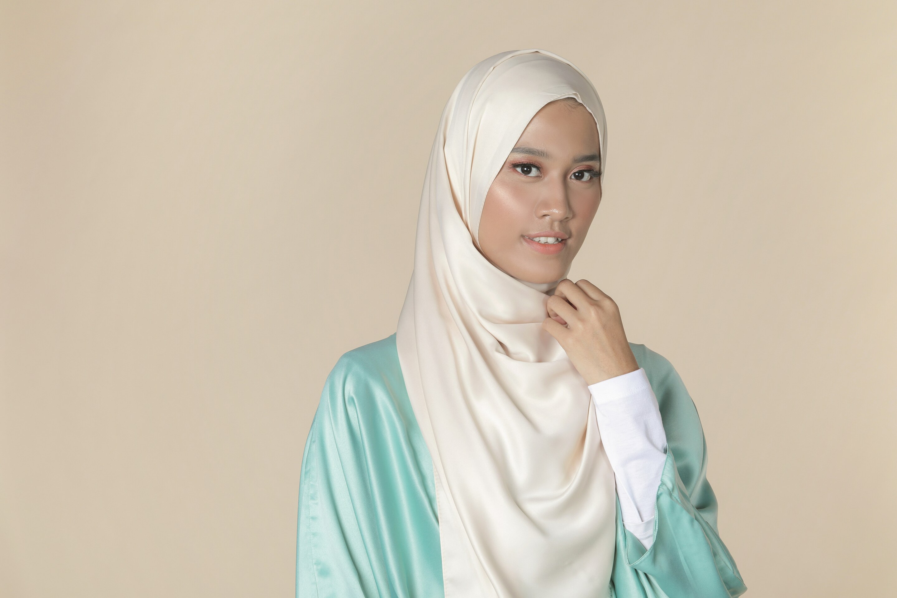 wanita asia sedang menggunakan jarum pentul untuk hijab panjang