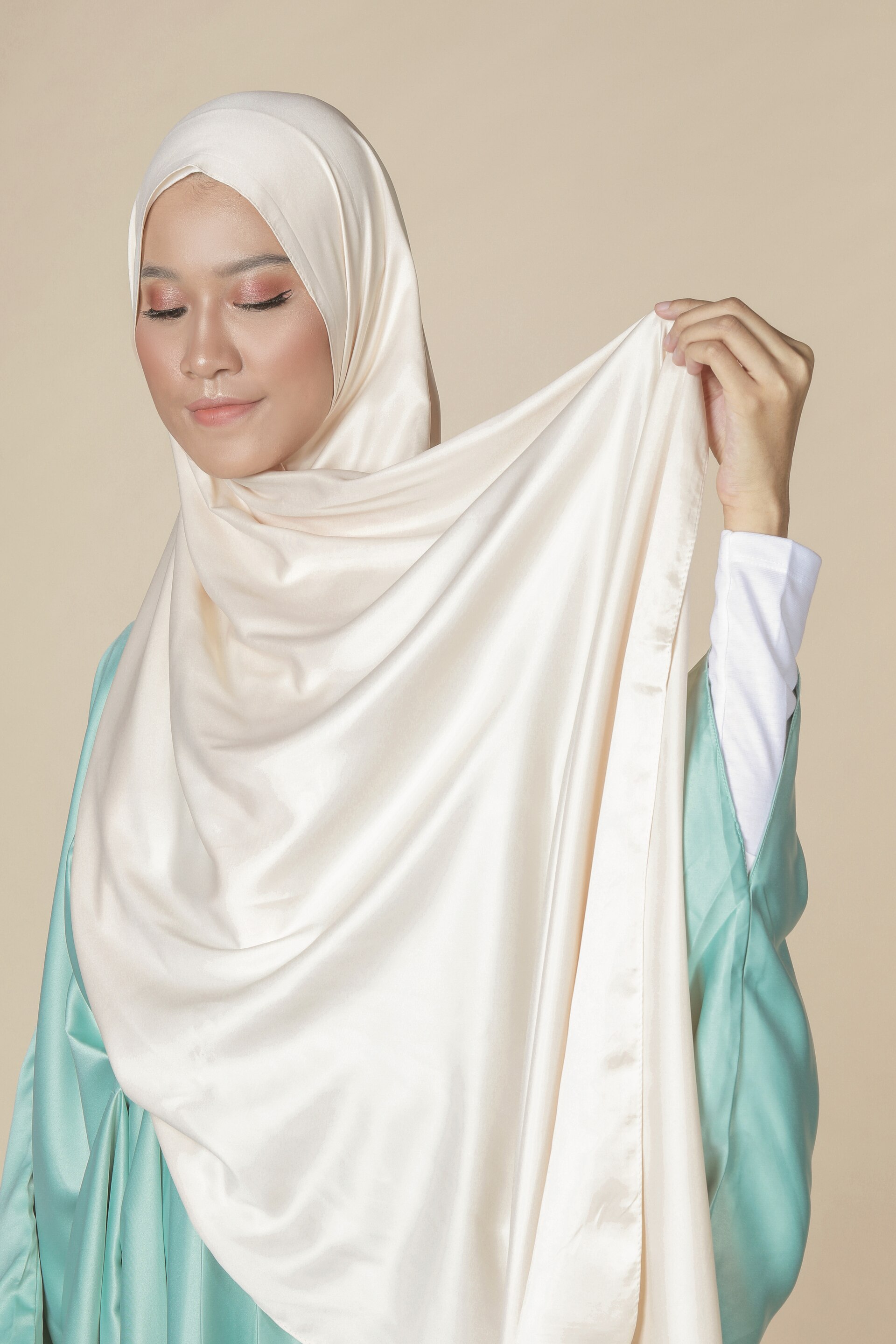 Wanita asia sedang melingkarkan hijab pashmina