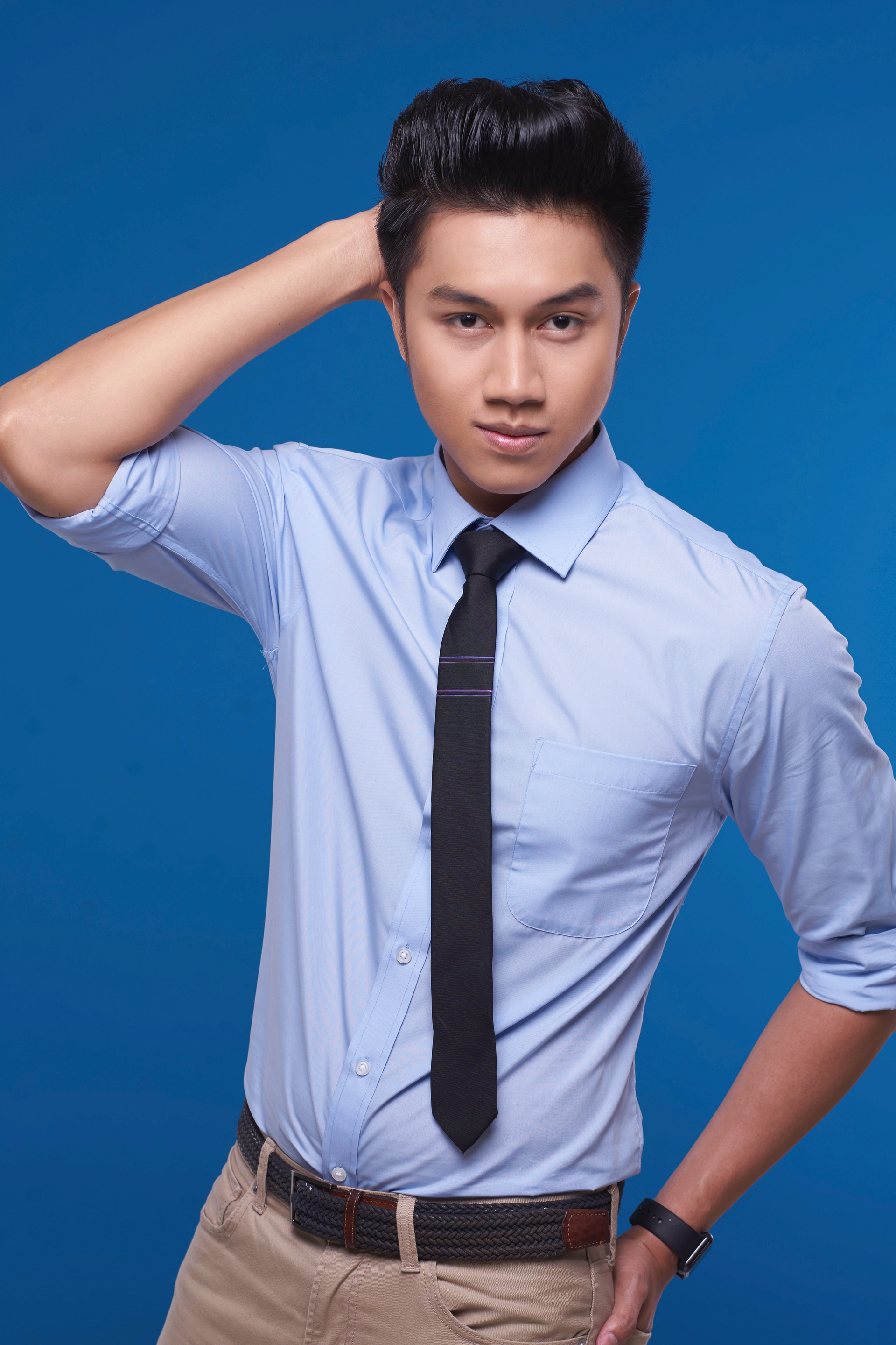 Pria asia dengan gaya rambut pompadour menyisir rambutnya dengan tangan