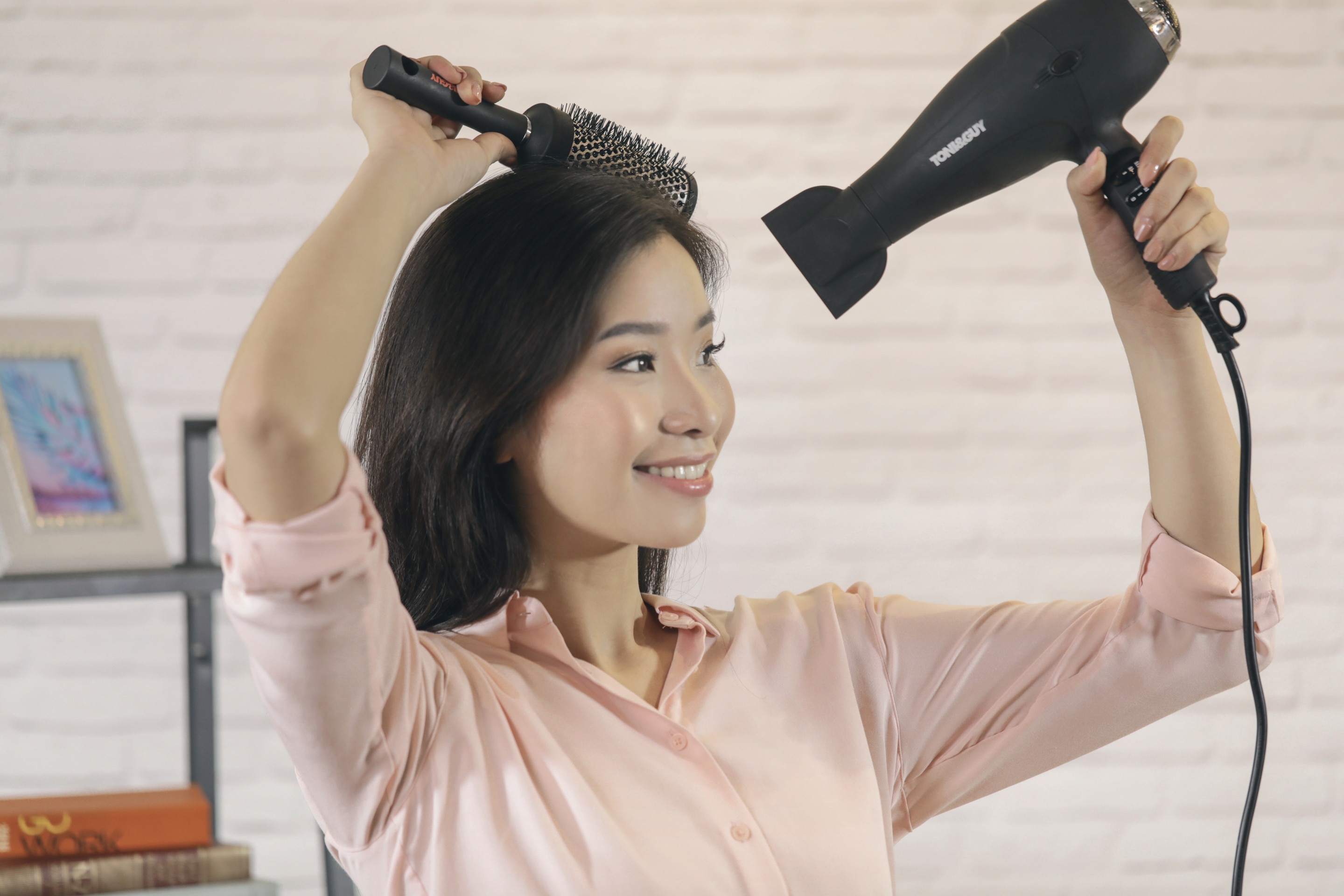 ผู้หญิงเอเชียผมยาวสีดำ กำลังไดร์ผม
