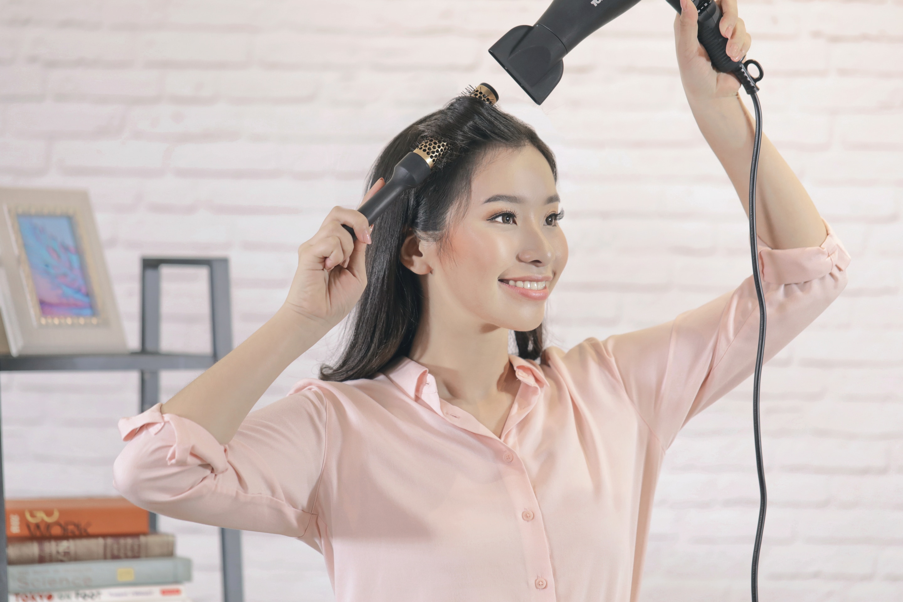 ผู้หญิงเอเชียผมยาวสีดำ กำลังไดร์ผม