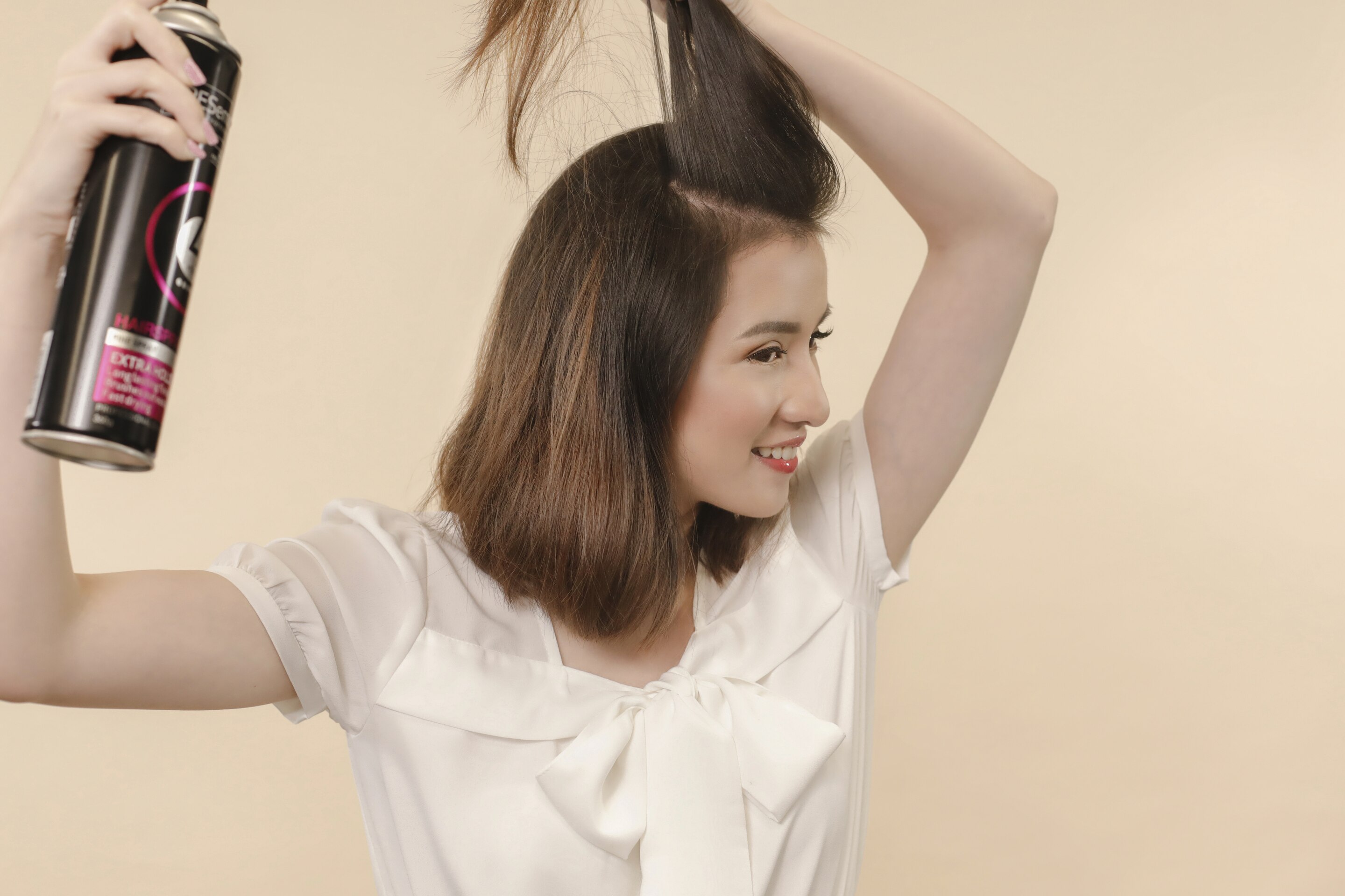 ผู้หญิงเอเชียผมสั้นสีดำ กำลังฉีดสเปรย์