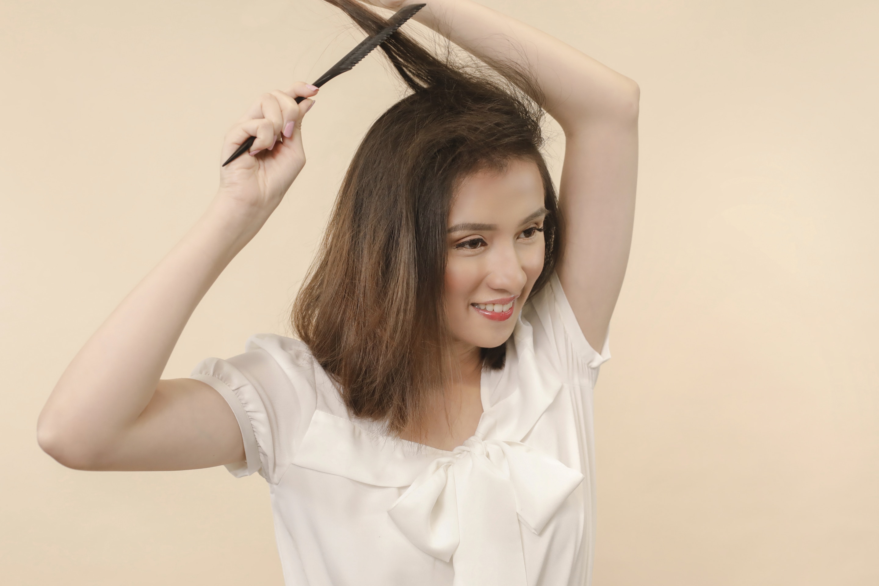 ผู้หญิงเอเชียผมสั้นสีดำ กำลังยีผม