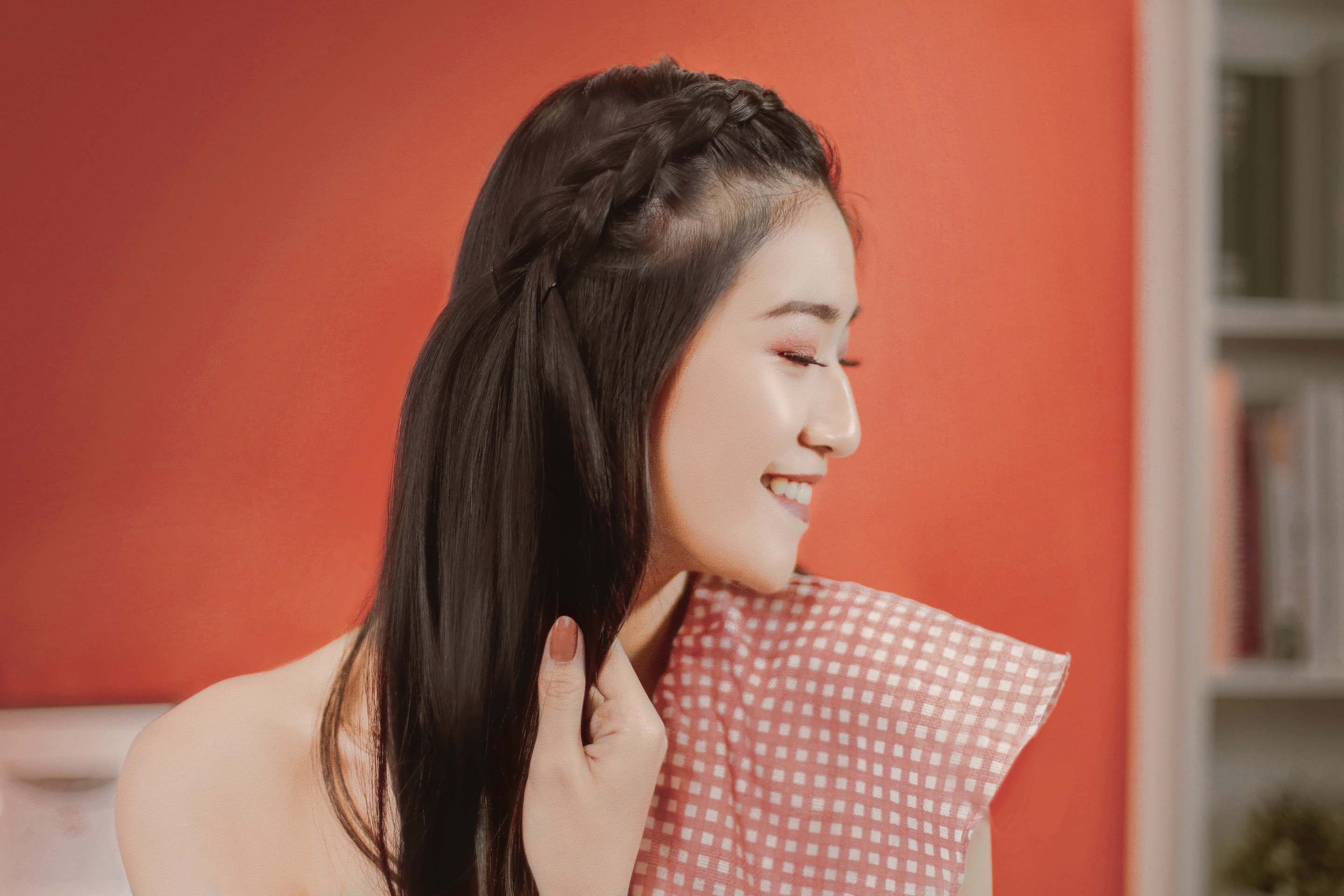 ผู้หญิงเอเชียผมยาวสีดำ กำลังถักเปียดัตช์