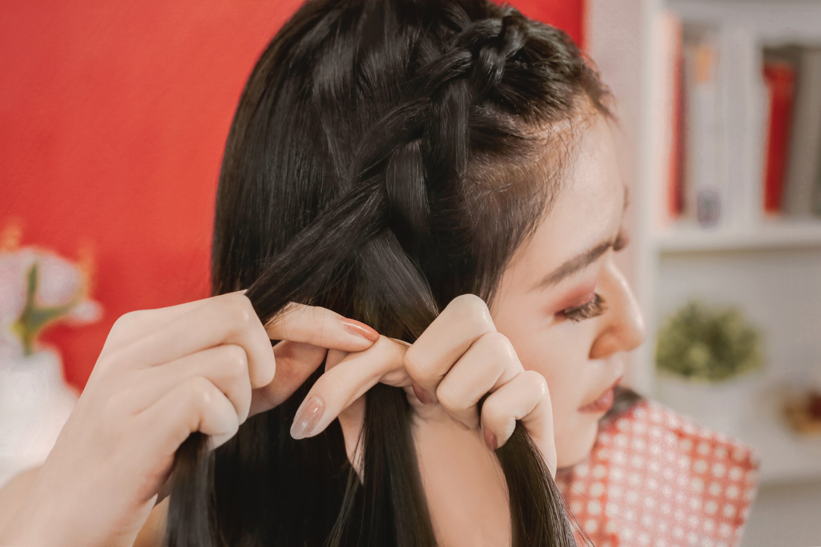 ผู้หญิงเอเชียผมยาวสีดำ กำลังถักเปียดัตช์