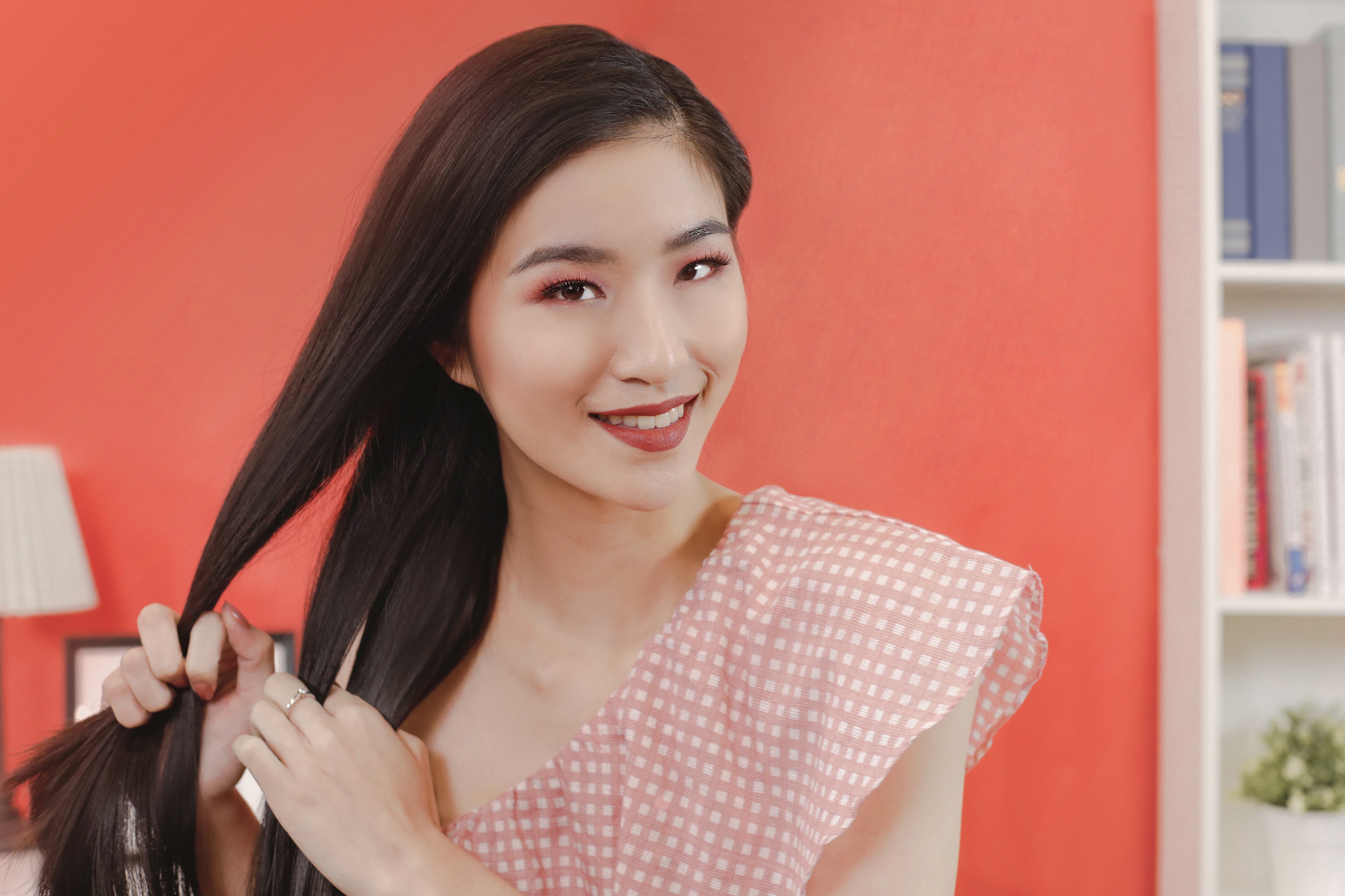 ผู้หญิงเอเชียผมยาวสีดำ กำลังถักเปียสาม