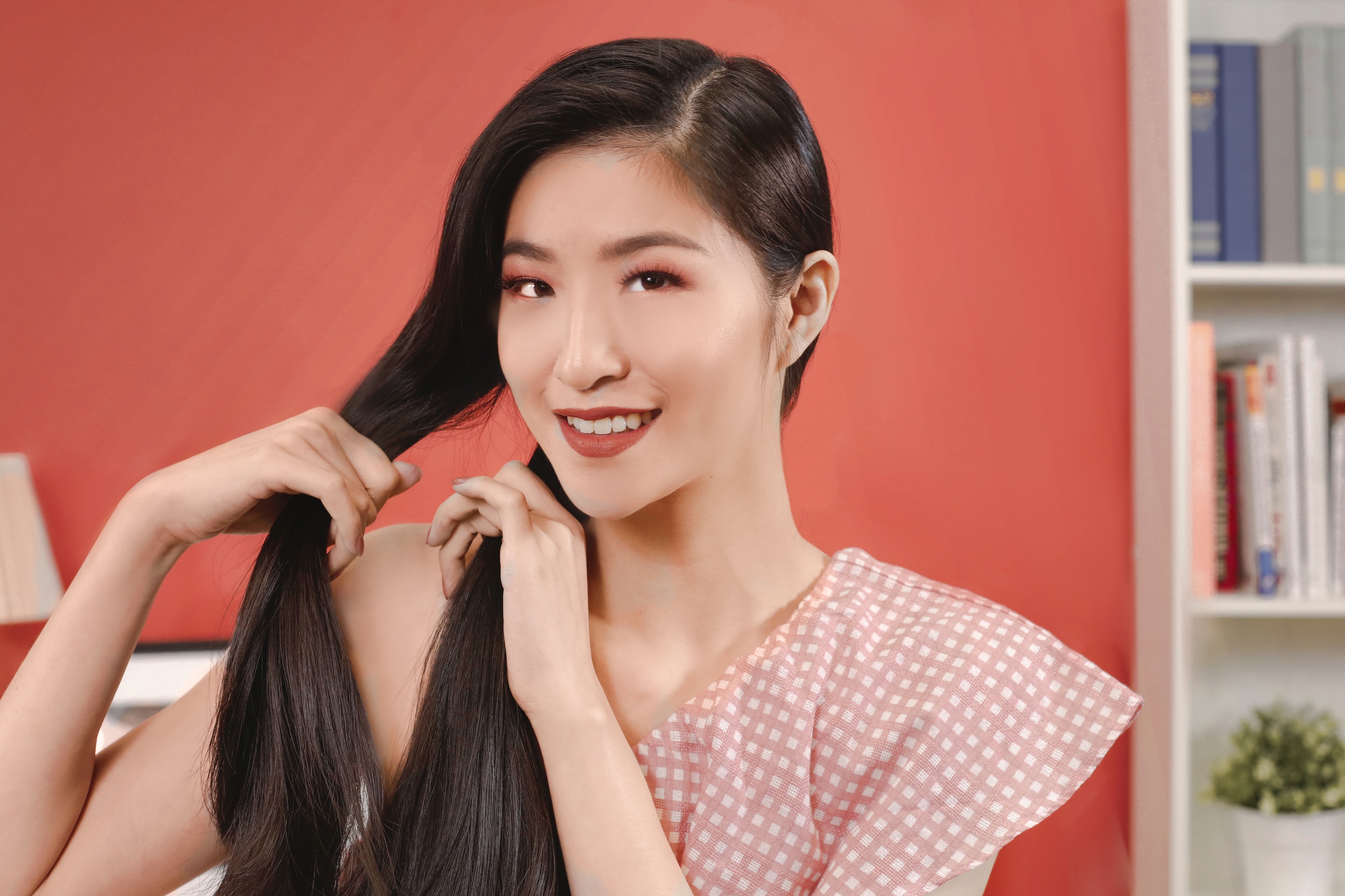 ผู้หญิงเอเชียผมยาวสีดำ กำลังถักเปียก้างปลา