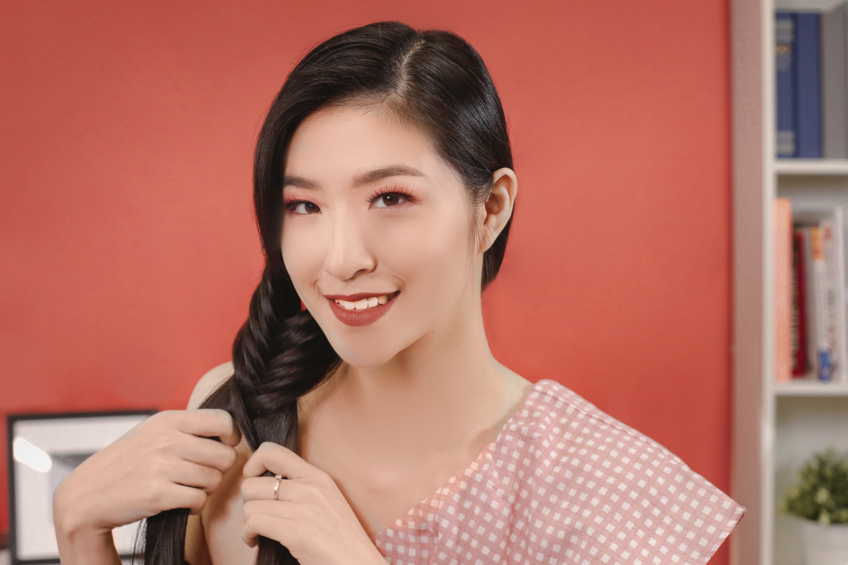 ผู้หญิงเอเชียผมยาวสีดำ กำลังถักเปียก้างปลา